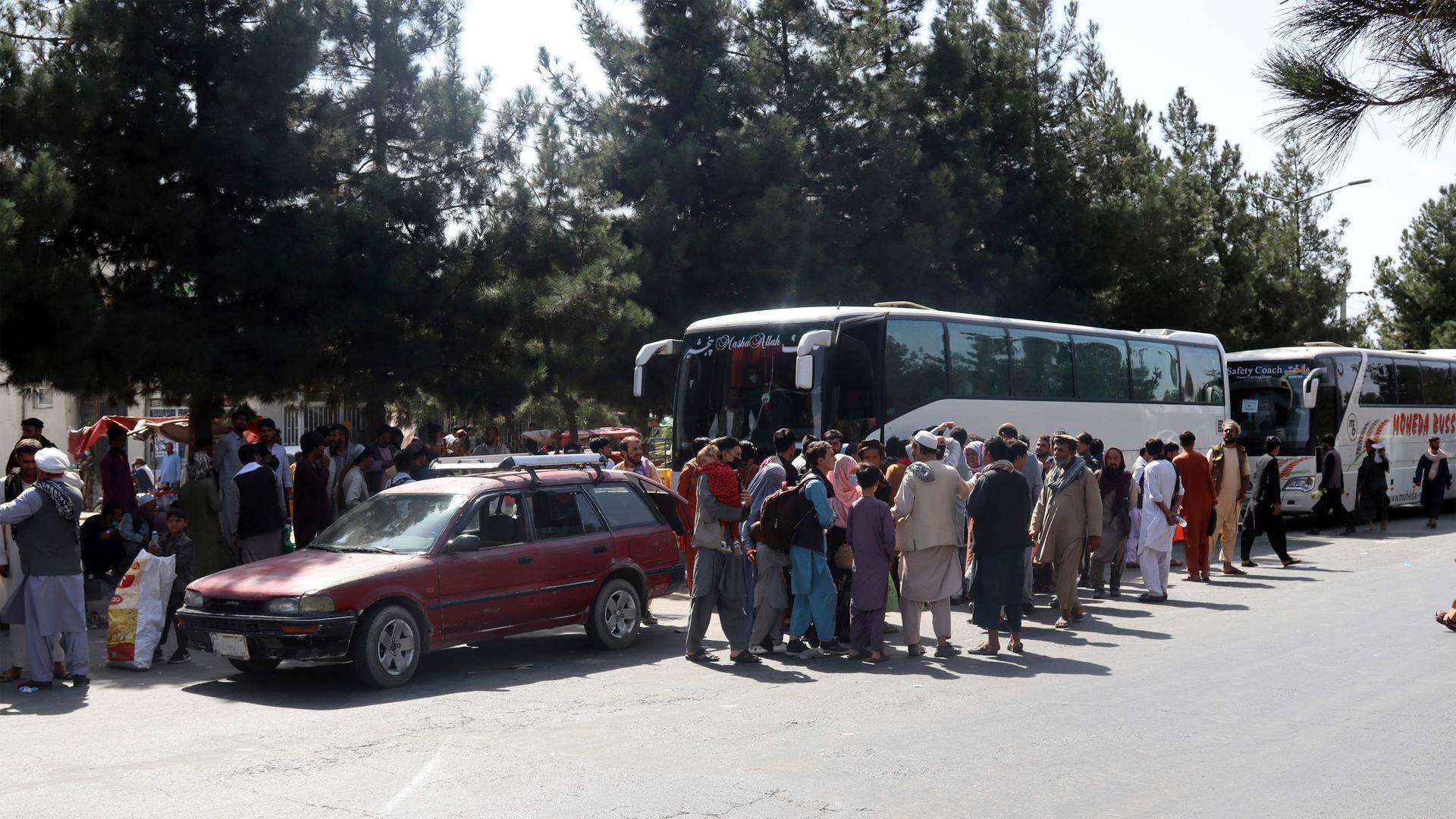 Hundreds of people, some holding documents, gather near an evacuation control checkpoint on the perimeter of the Hamid Karzai International Airport, in Kabul, Afghanistan, on Aug. 27, 2021.