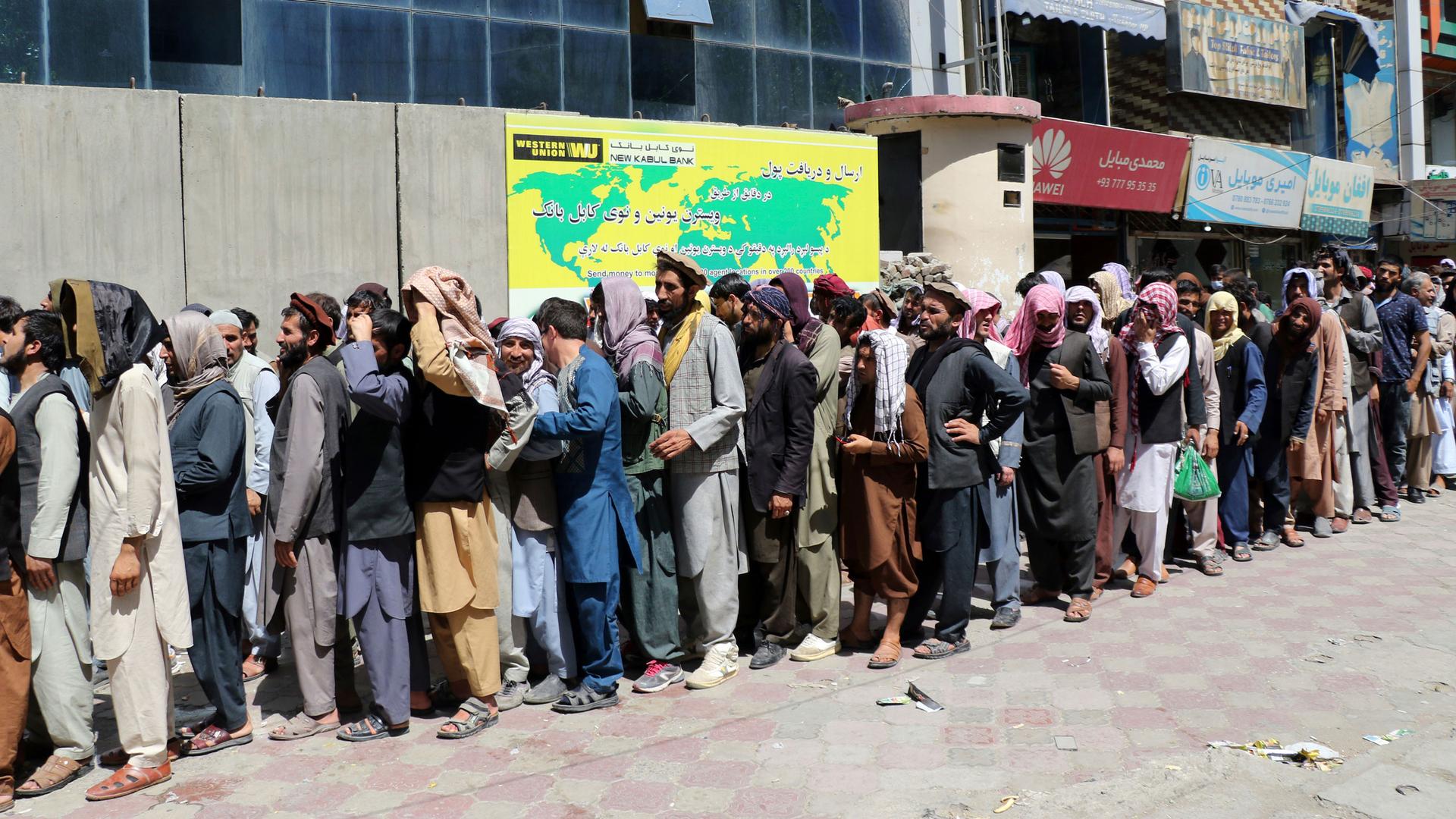 Afghans wait in front of Kabul Bank, in Kabul, Afghanistan, Wednesday, Aug. 25, 2021.