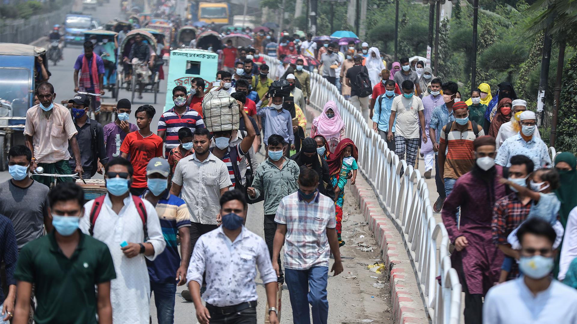 People wearing face masks as a precaution against the coronavirus leave the city to travel to their native places ahead of Eid al-Fitr in Dhaka, Bangladesh