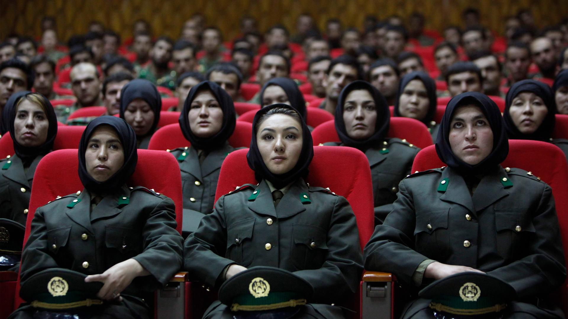 Newly trained female officers from the Afghan National Army sit in front seats as a new batch of officers attend their graduation ceremony at National Army's training center in Kabul on Sept. 23, 2010. 