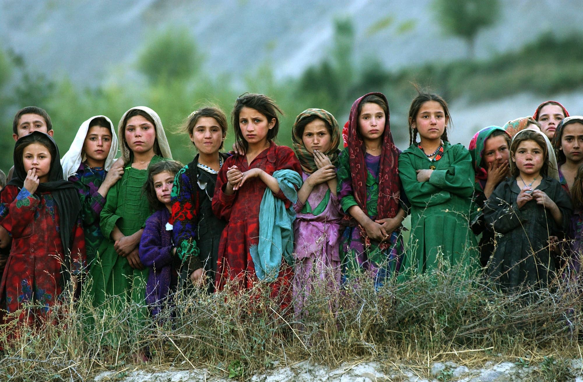Local girls look at UN workers unloading ballot kits from a UN helicopter in Ghumaipayan Mahnow village, some 256 miles)northeast of Kabul, Afghanistan, on Oct. 4, 2004. By air was the only way to deliver the electoral material in the inaccessible areas o