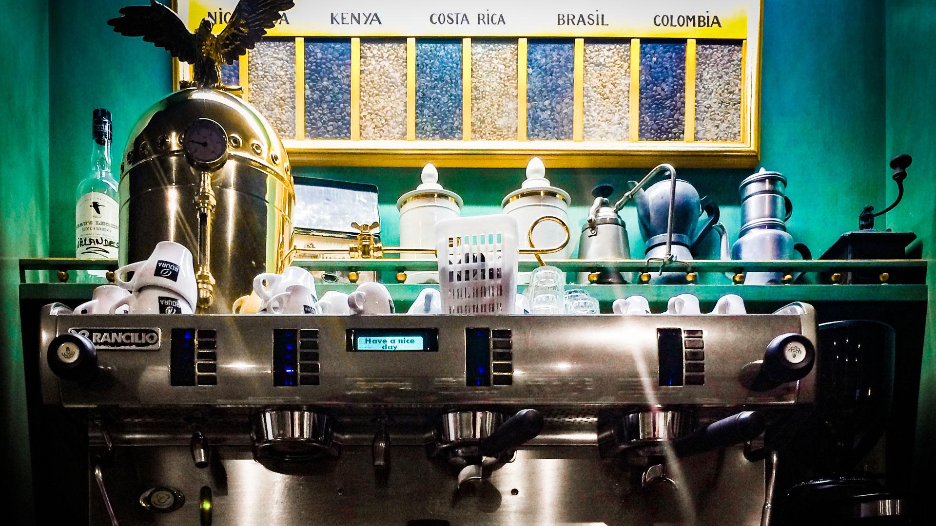 An espresso machine with coffee beans from around the world featured in the background. 