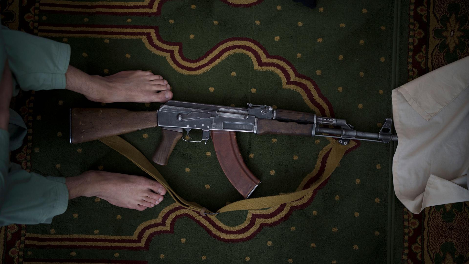 A Taliban fighter lays his AK-47 rifle down during Friday prayers at a mosque in Kabul, Afghanistan, Friday, Sept. 10, 2021. 