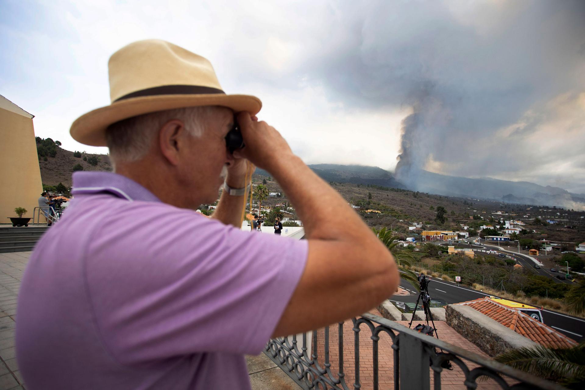 A man looks out towards the eruption of a volcano near El Paso on the island of La Palma in the Canaries, Spain, Monday, Sept. 20, 2021. 