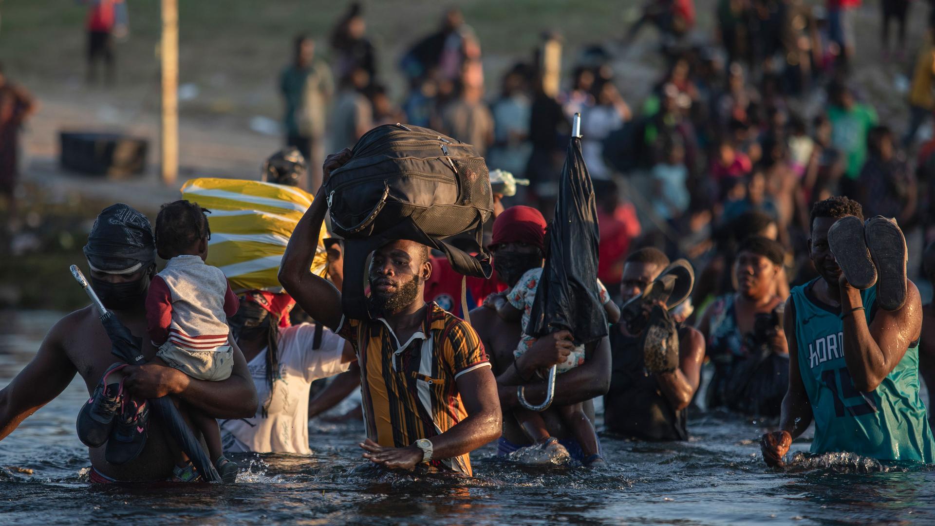 Migrants, many from Haiti, wade across the Rio Grande river from Del Rio, Texas, to return to Ciudad Acuña, Mexico, Monday, Sept. 20, 2021, to avoid deportation from the US. 