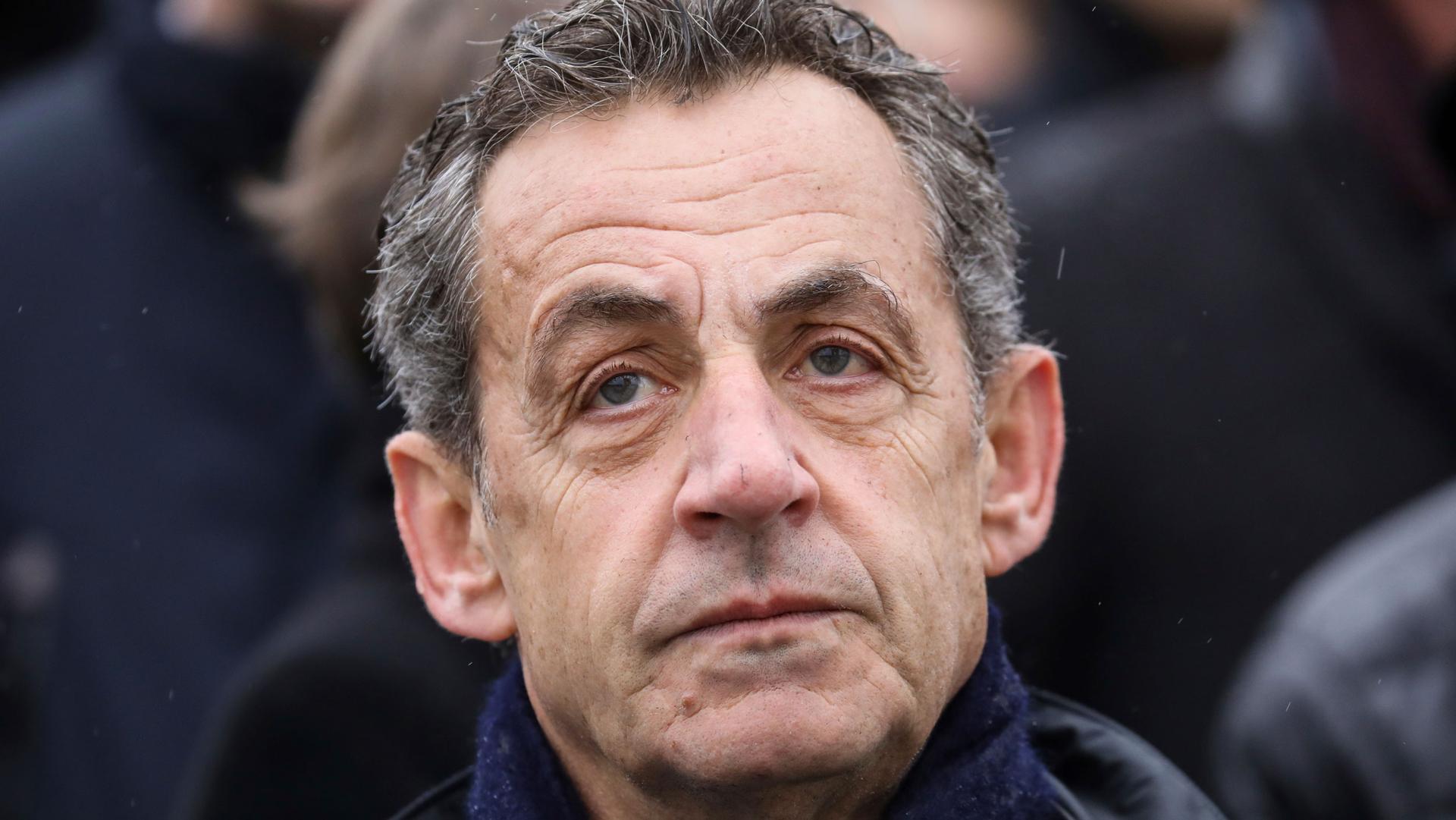 A close up photograph of French former president Nicolas Sarkozy who is wearing a scarf.