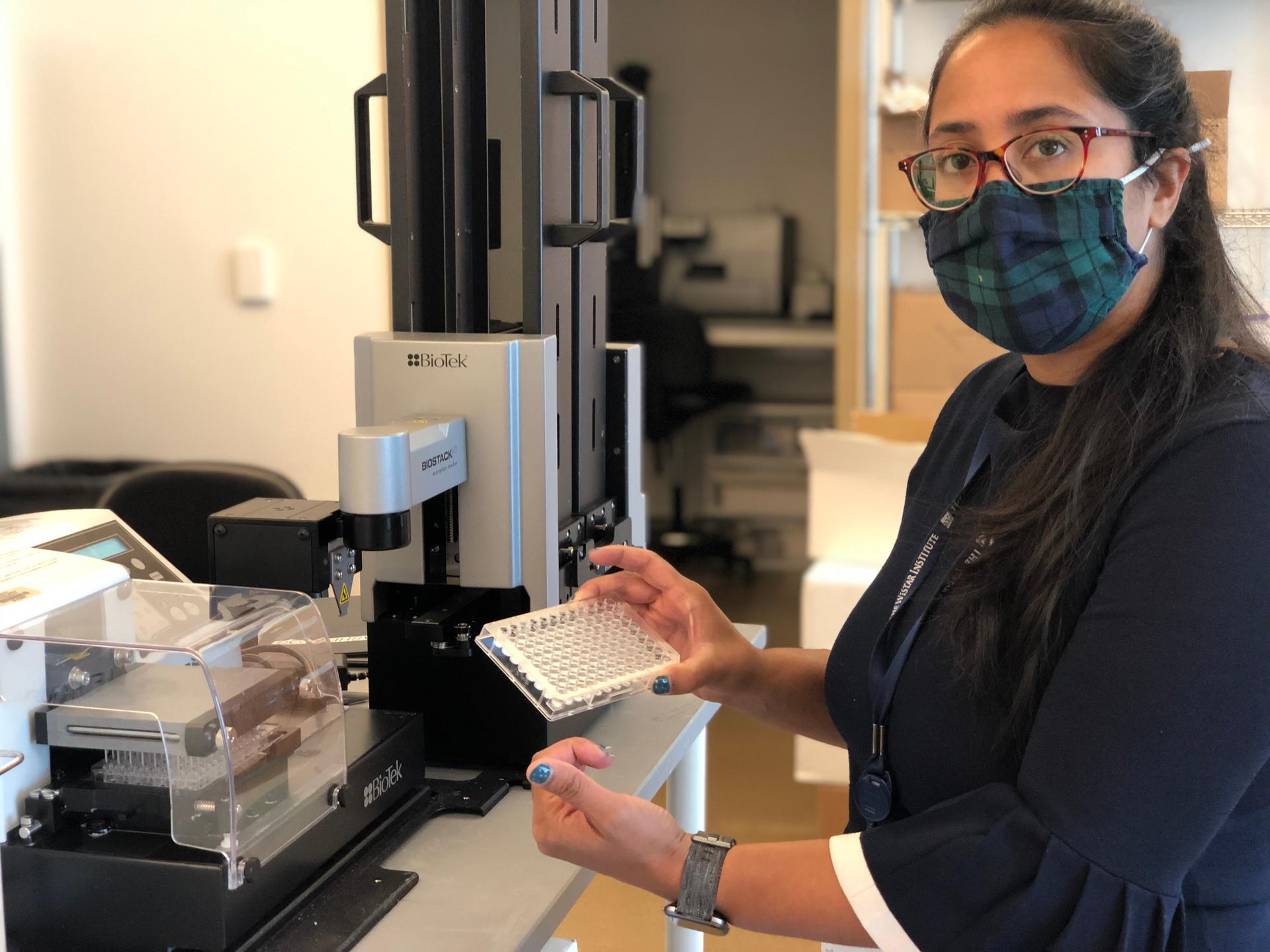 Ami Patel, a scientist at The Wistar Institute in Philadelphia, Pennsylvania, holds a “plate” used to test blood serum samples for antibodies from vaccines the lab is developing. One of them is for COVID-19.