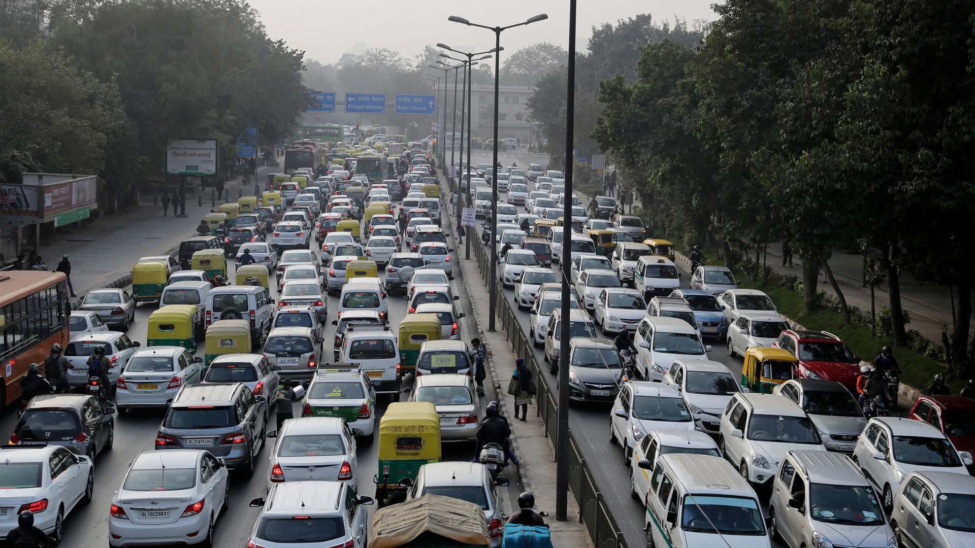 Vehicles move slowly through a traffic intersection after the end of a two-week experiment to reduce the number of cars to fight pollution in in New Delhi, India
