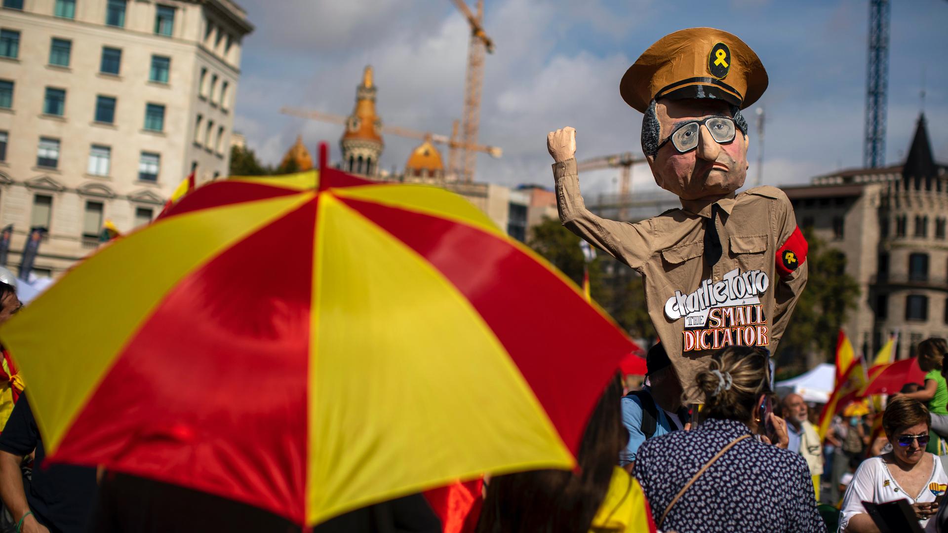 A demonstrator holds a paper doll representing regional Catalan President Quim Torra, as they celebrate a holiday known as "Dia de la Hispanidad" or Spain's National Day in Barcelona, Spain, Oct. 12, 2019. Spain commemorates Christopher Columbus' arrival 
