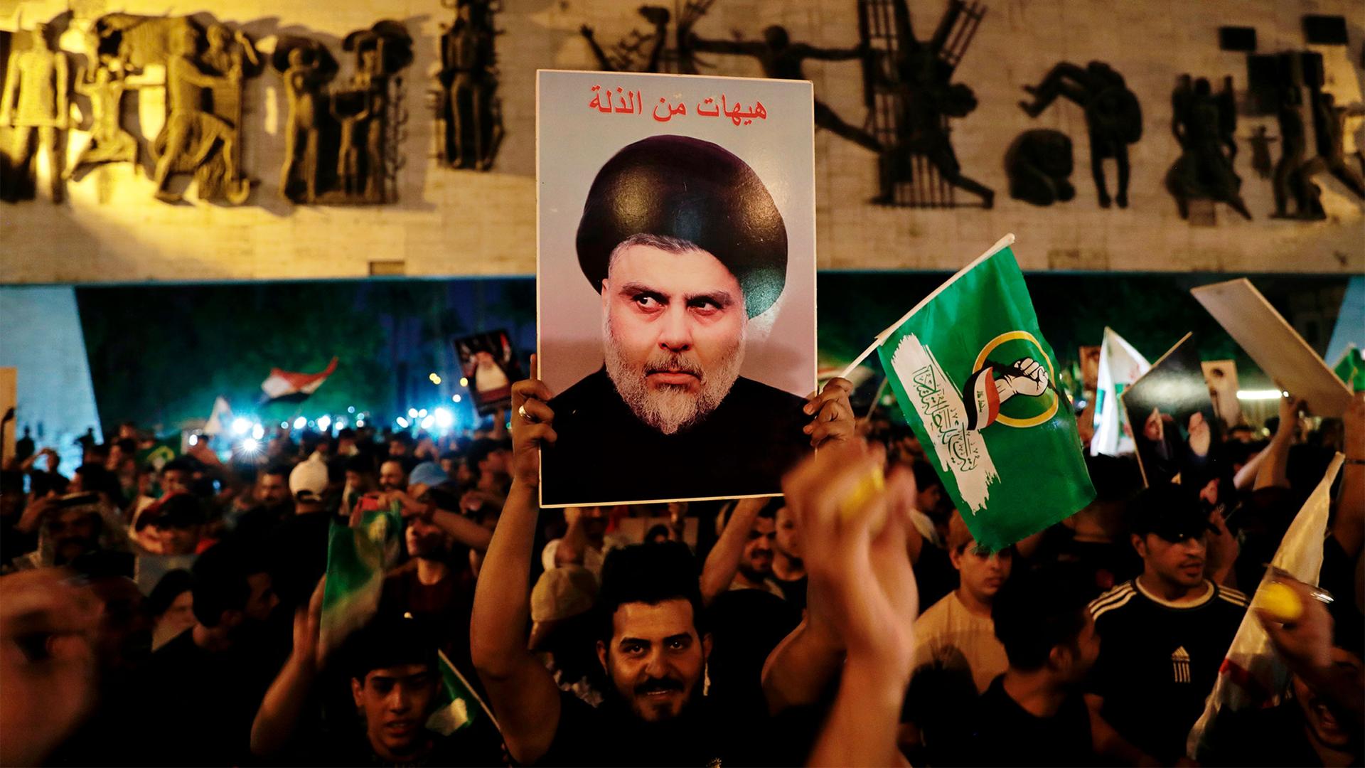 Followers of Muqtada al-Sadr celebrate holding his posters, after the announcement of the results of the parliamentary elections in Tahrir Square, Baghdad, Iraq