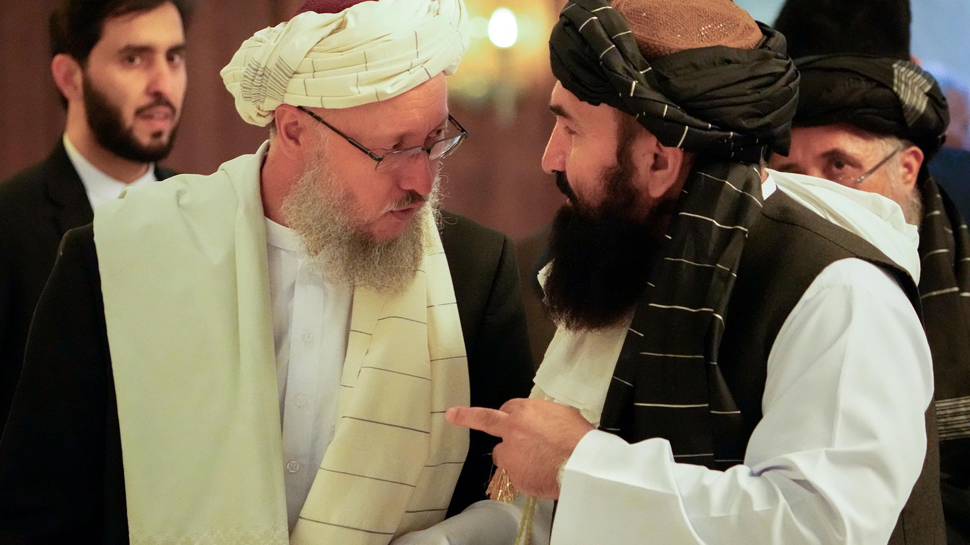 Abdul Salam Hanafi, a deputy prime minister in the Taliban's interim government, left, speaks with acting Foreign Minister of Afghanistan, Taliban official Amir Khan Muttaqi during talks involving Afghan representatives in Moscow, Russia