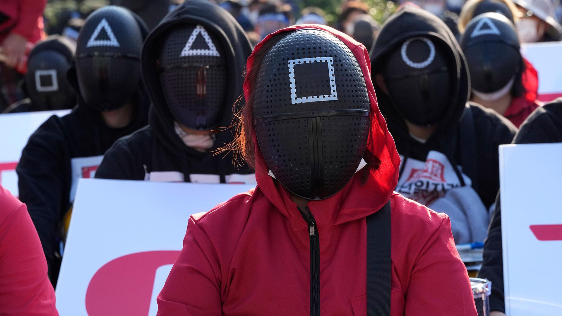 Members of the South Korean Confederation of Trade Unions wearing masks and costumes inspired by the Netflix original Korean series "Squid Game" attend a rally demanding job security in Seoul, South Korea