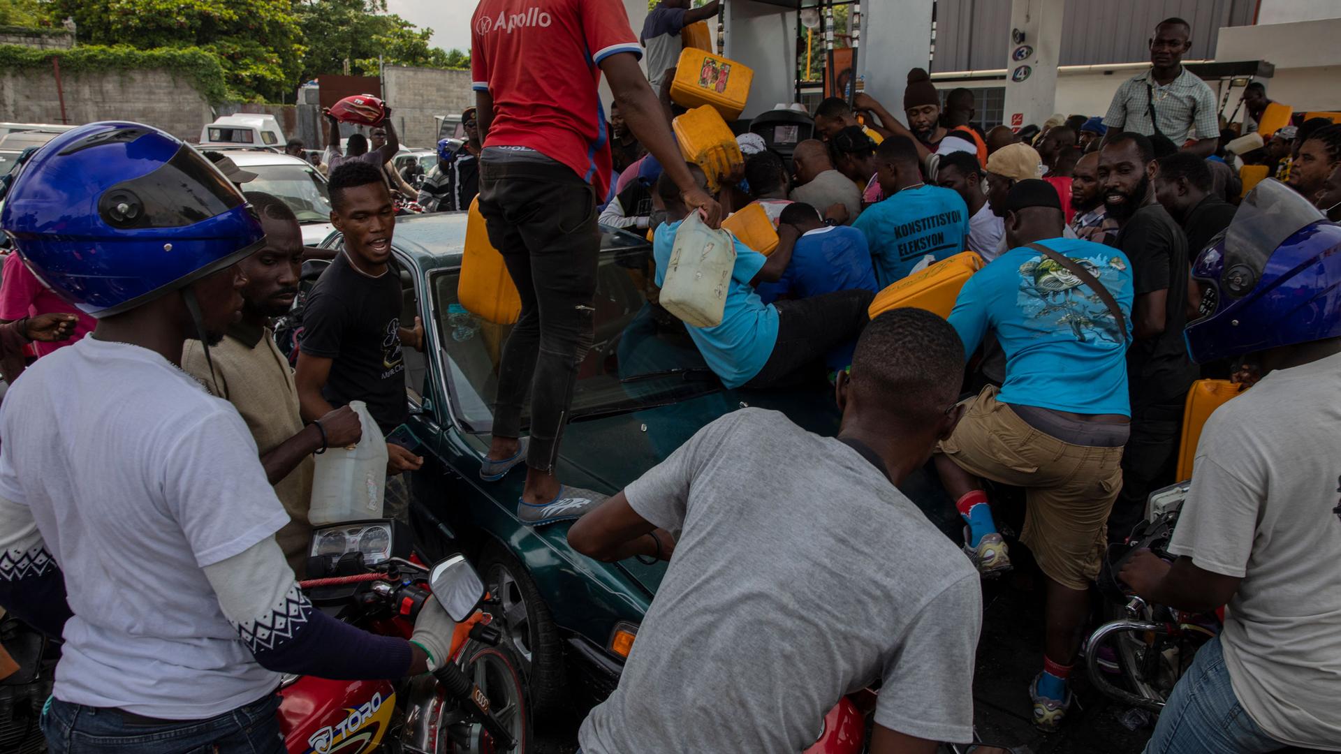 People push and shove as they try to get their tanks filled at a gas station in Port-au-Prince, Haiti, Wednesday, Sept. 22, 2021.