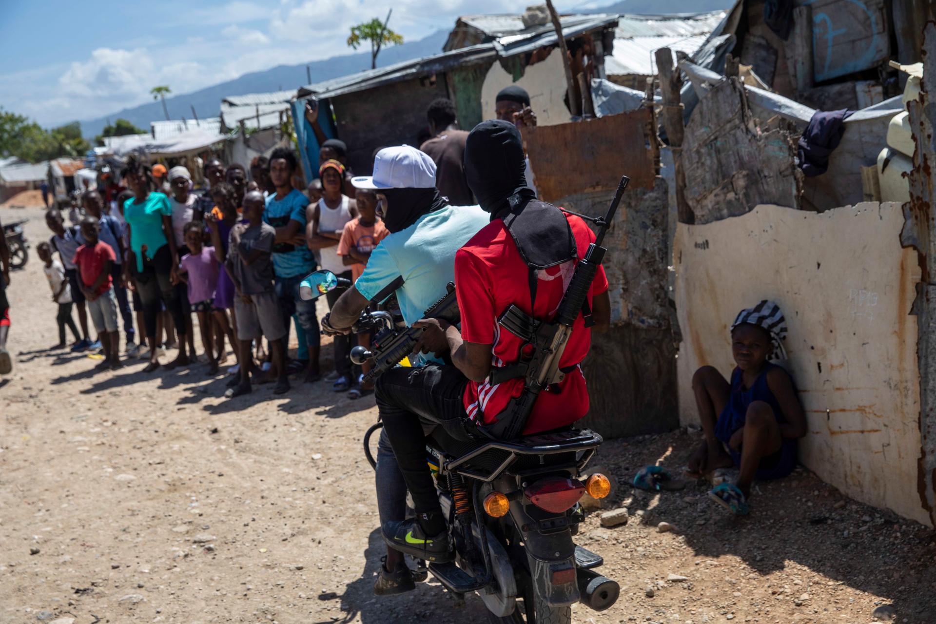 G9 coalition gang members ride a motorcycle through the Wharf Jeremy street market in Port-au-Prince, Haiti, on Oct. 6, 2021.