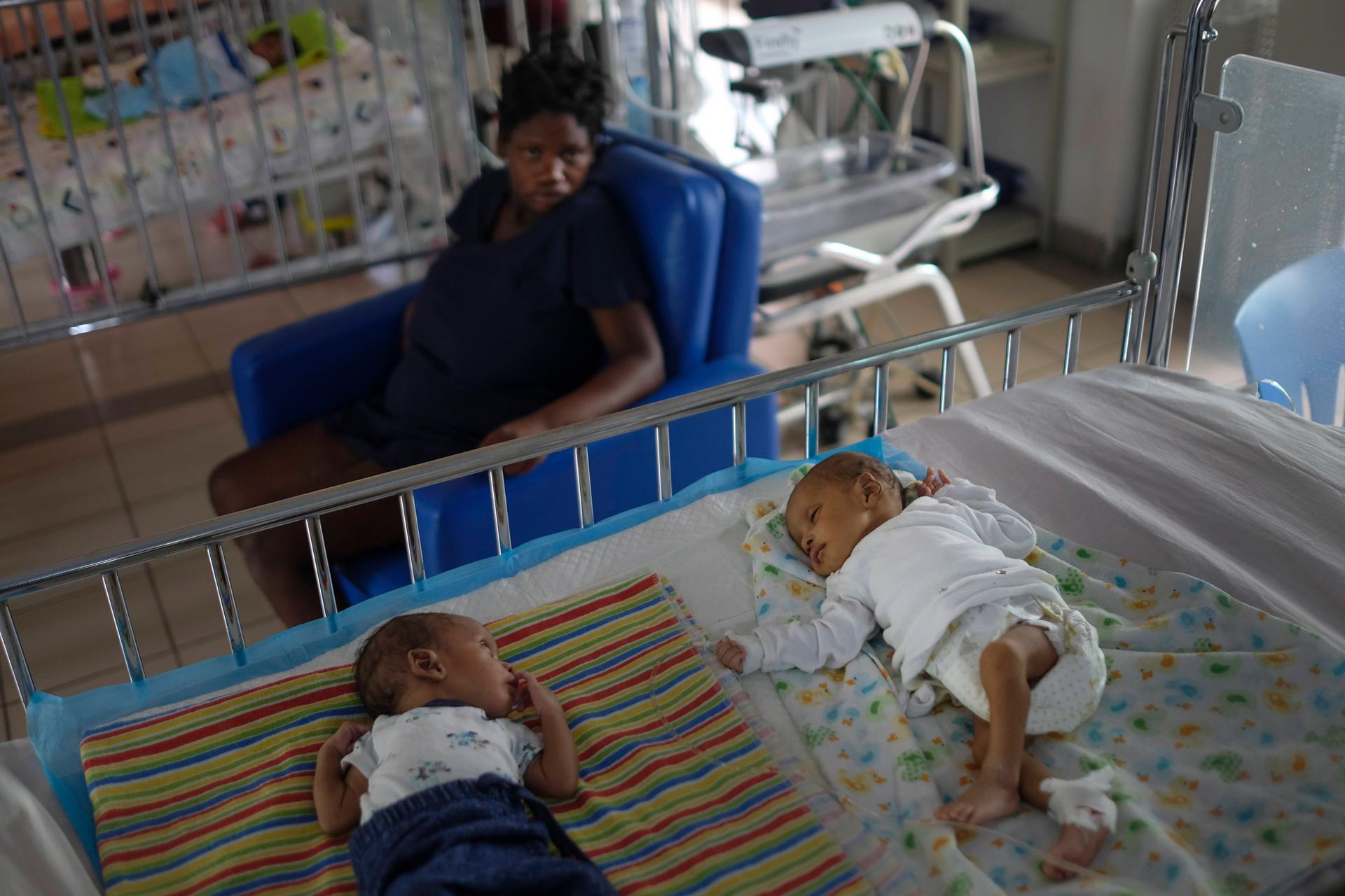 Twins rest on a bed at the Saint Damien Pediatric Hospital of Port-au-Prince, Haiti, on Oct. 24, 2021. Haiti's capital has been brought to the brink of exhaustion by fuel shortages and the capital's main pediatrics hospital says it has only three days of