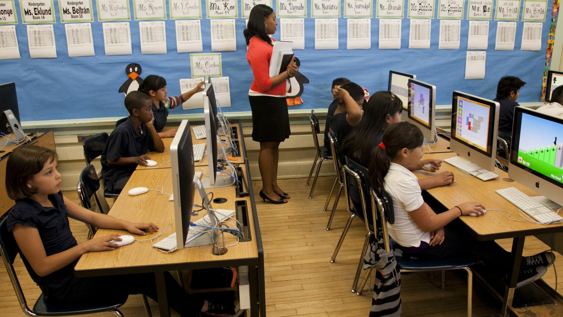 Elementary students sit in a computer lab at school
