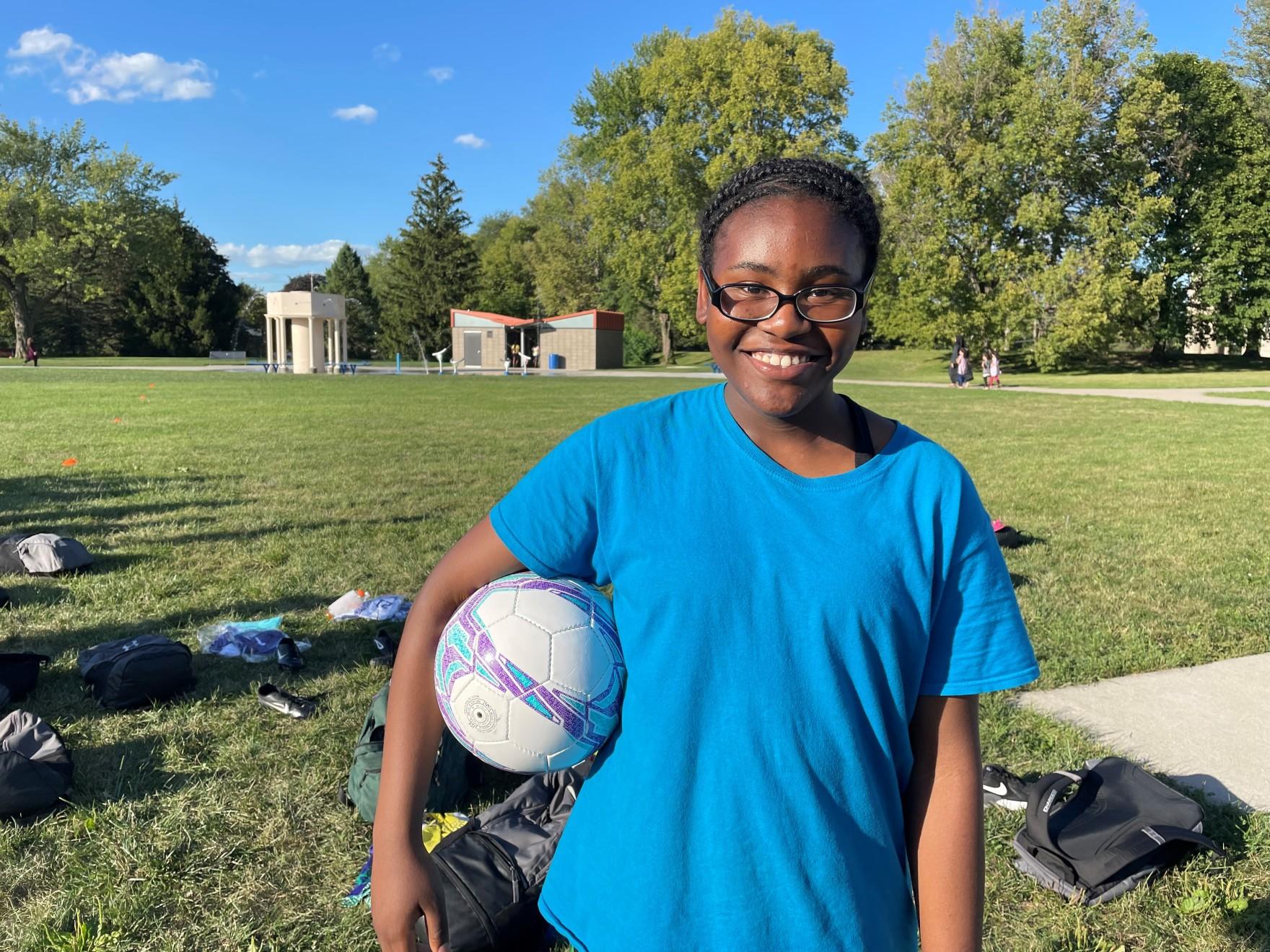 Nadege Lenge, 11, poses with her soccer ball