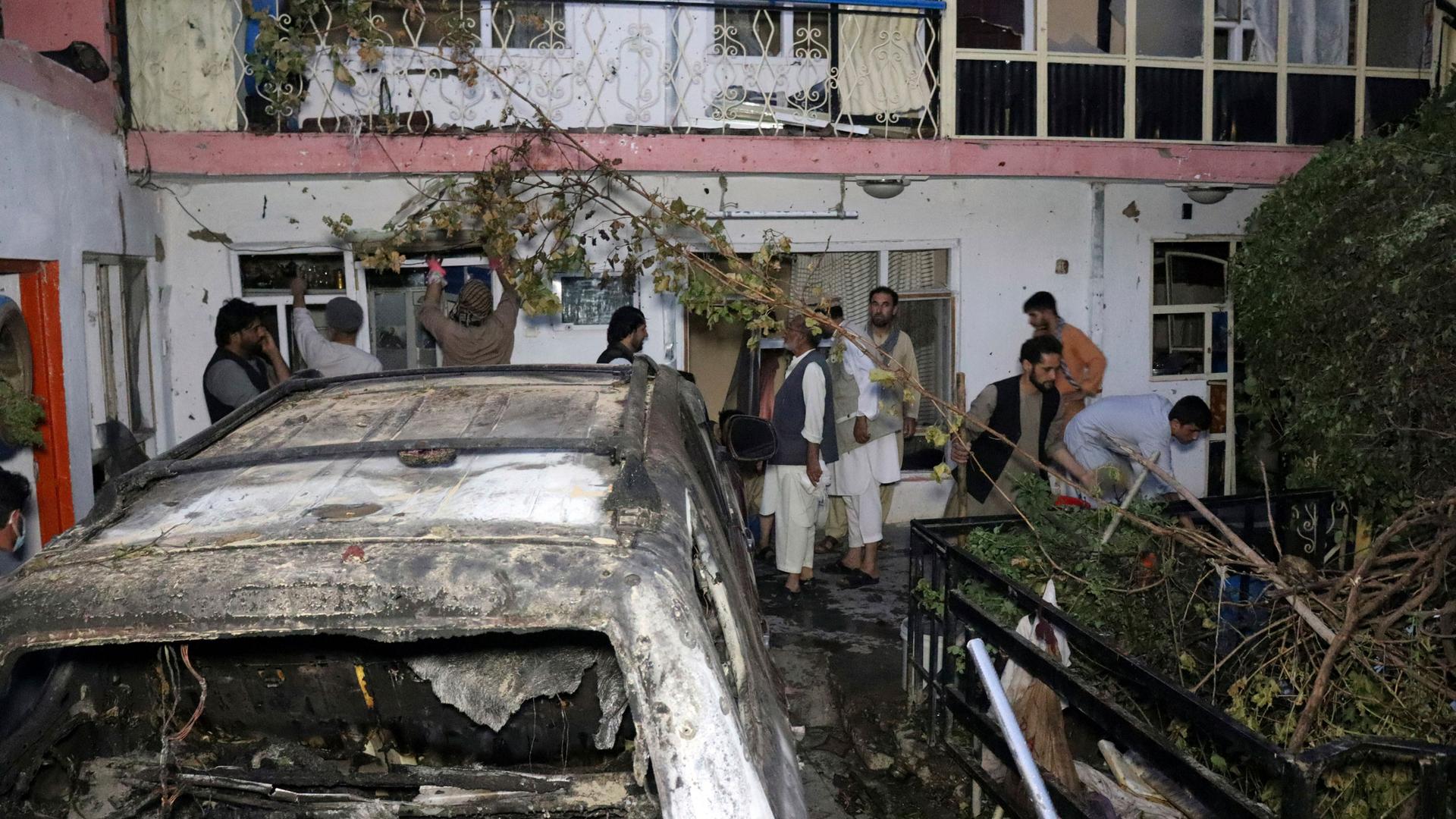 In this Sunday, Aug. 29, 2021 file photo, Afghans inspect damage of Ahmadi family house after US drone strike in Kabul, Afghanistan.