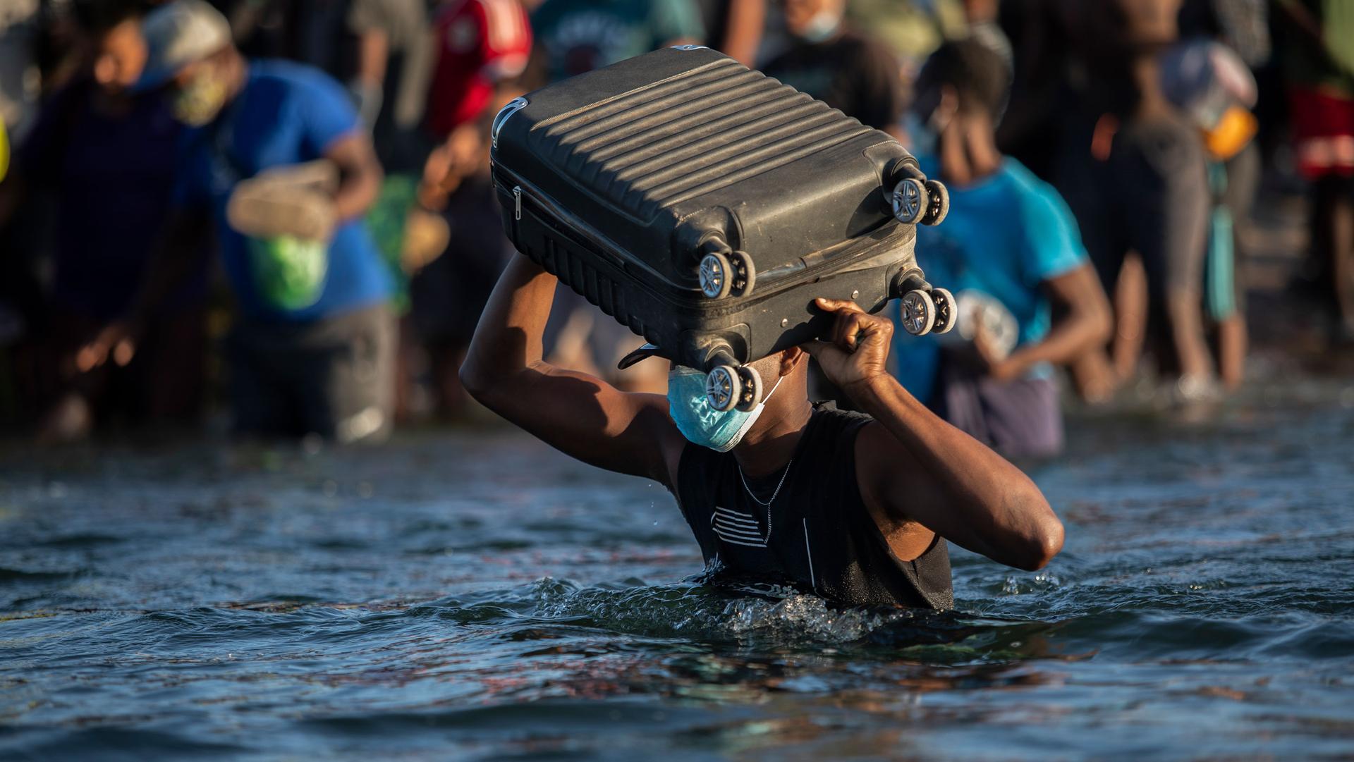 Migrants, many from Haiti, wade across the Rio Grande river from Del Rio, Texas, to return to Ciudad Acuña, Mexico, Sept. 20, 2021, to avoid deportation from the US. 