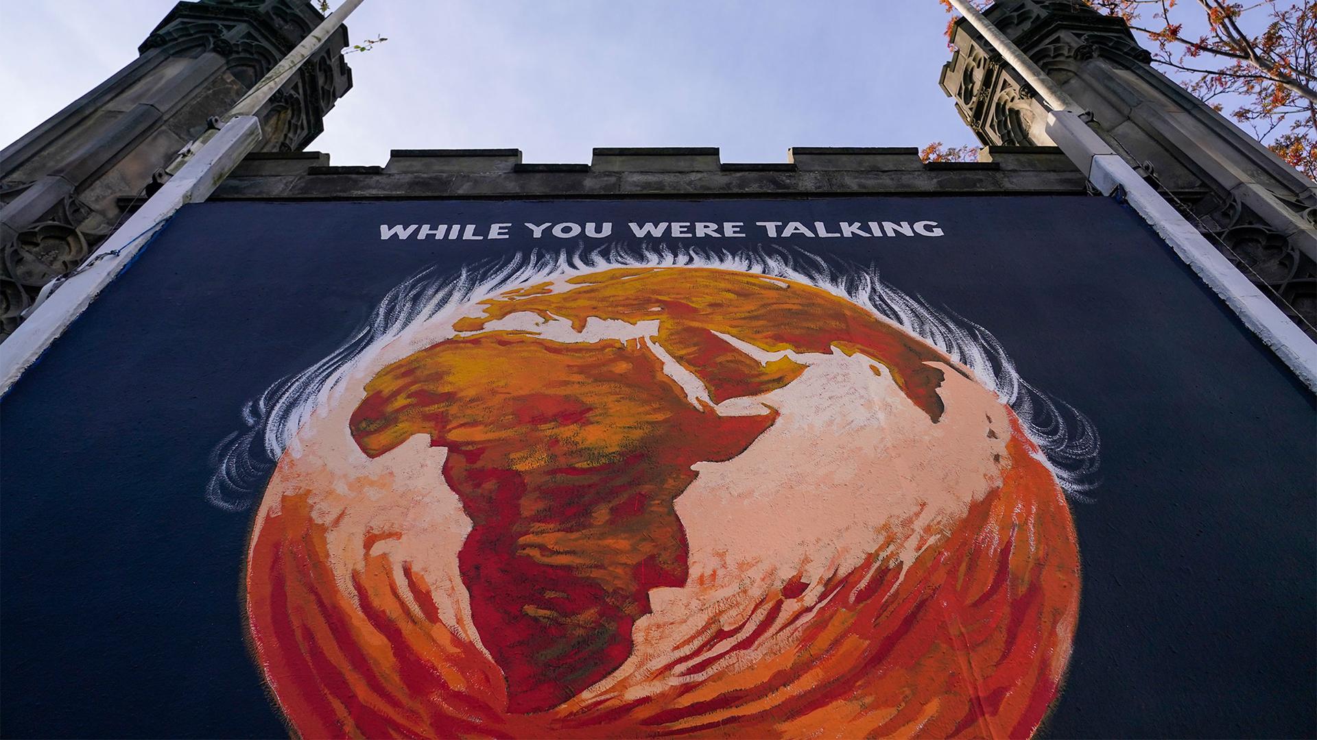 A panel depicting Planet Earth and a message reading 'While you were Talking,’ regarding the COP26 Summit is displayed on St John's Church, in Edinburgh, Scotland