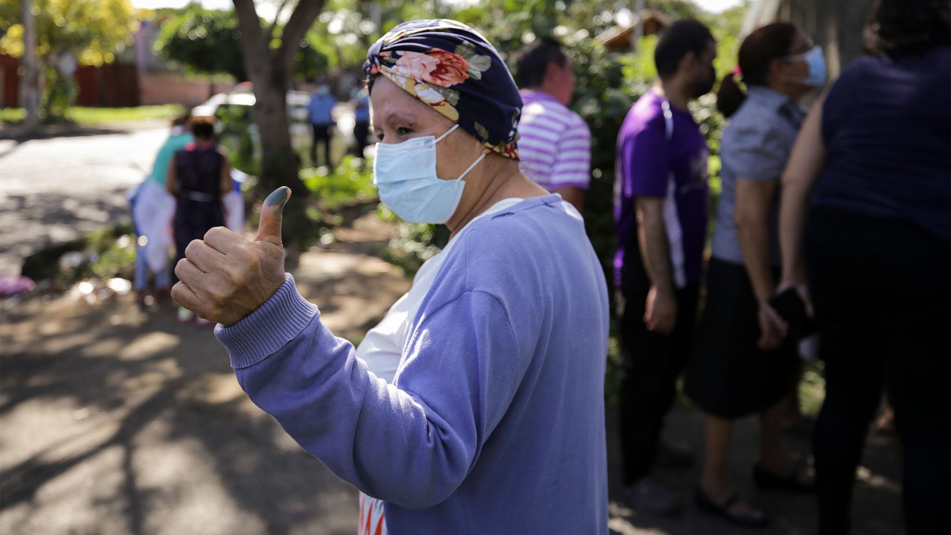 A woman shows her ink-stained finger after casting her vote during general elections in Managua, Nicaragua