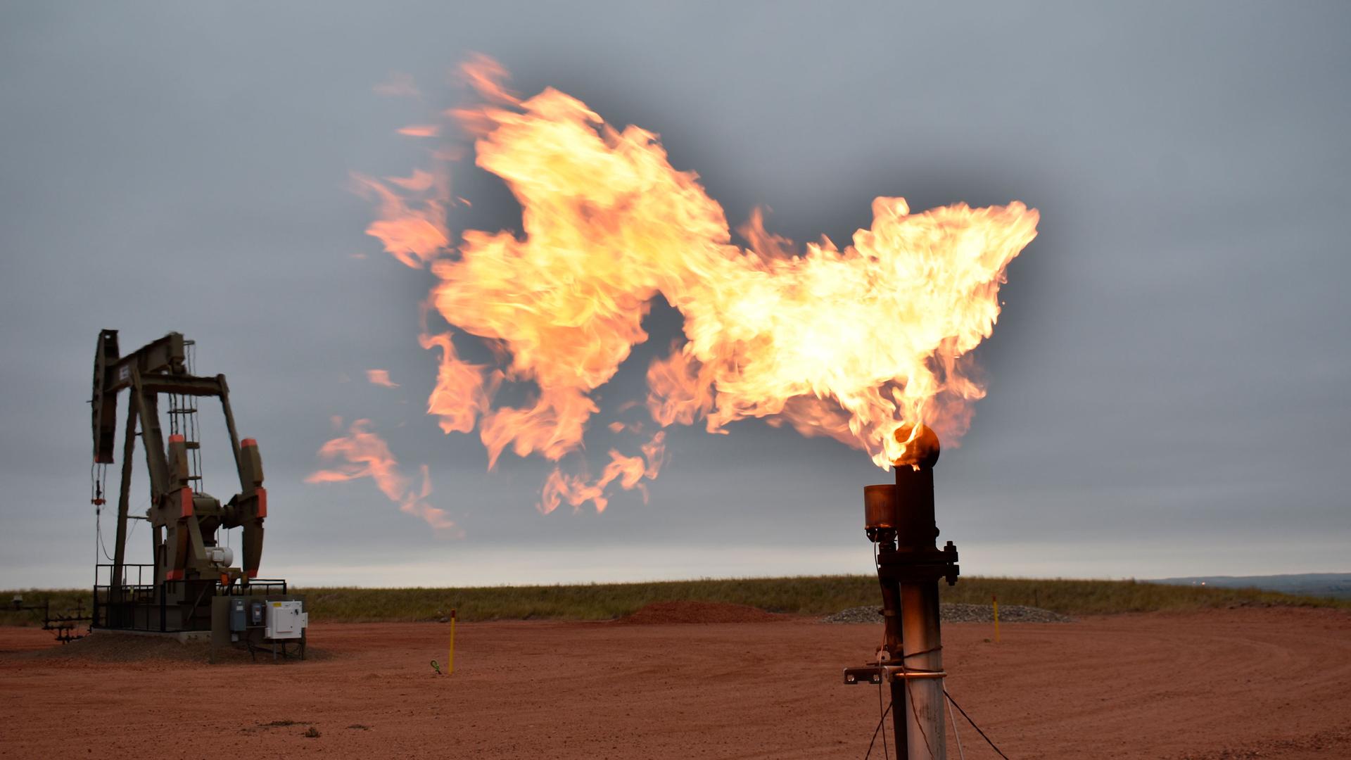 A flare burns natural gas at an oil well on Aug. 26, 2021, in Watford City, North Dakota.