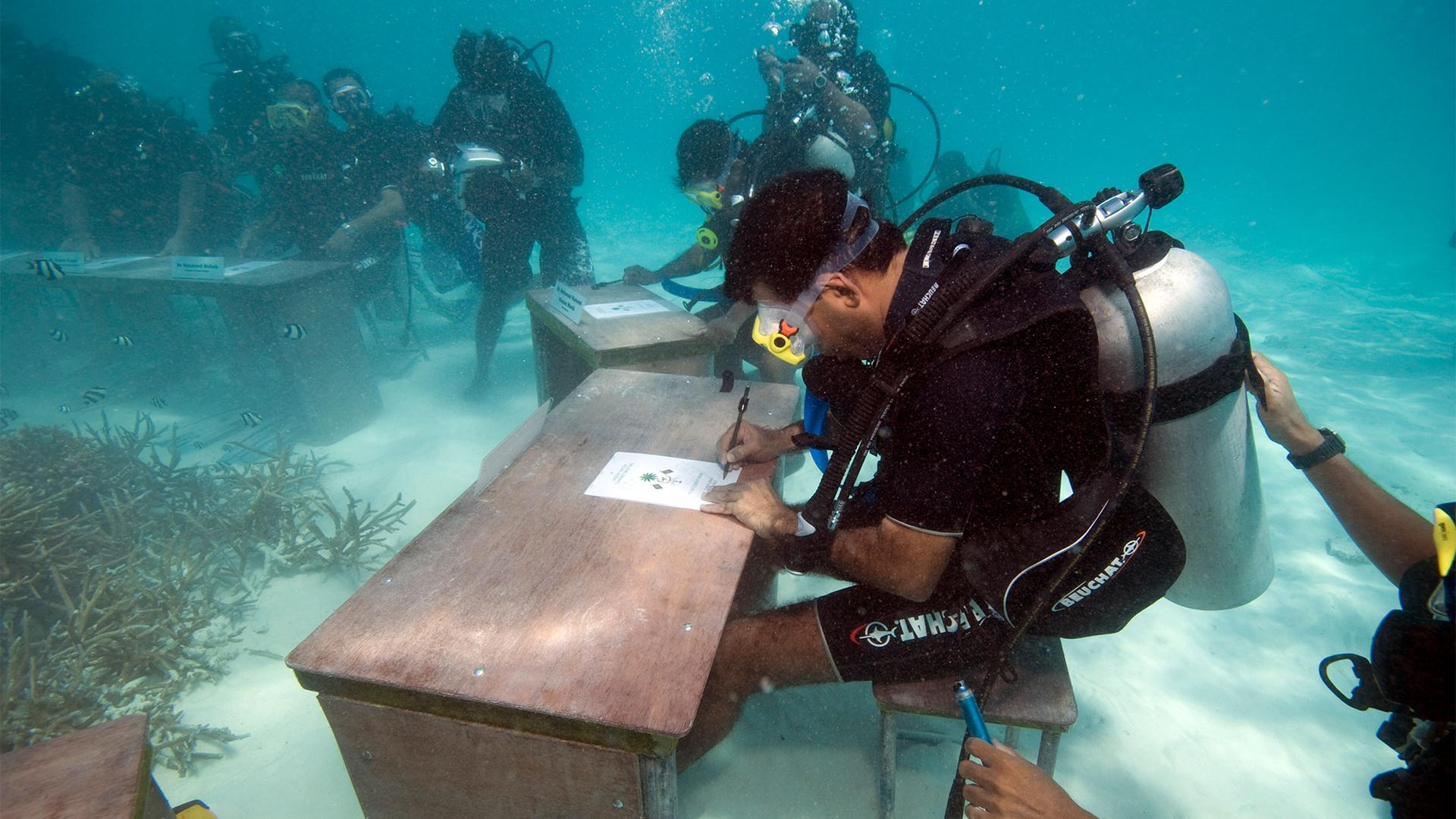 Maldivian President Mohammed Nasheed signs a document underwater calling on all countries to cut down their carbon dioxide emissions in Girifushi, about 20 minutes by speedboat from the capital Male, Maldives