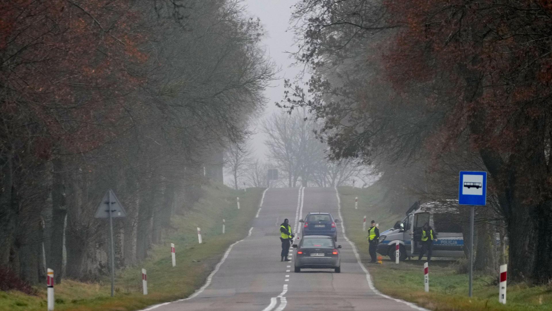 Polish police officers check cars near the border to Belarus, that was closed because of a large group of migrants camping in the area on the Belarus side who had tried to push their way into Poland and into the European Union, in Kuznica, Poland, Thursda