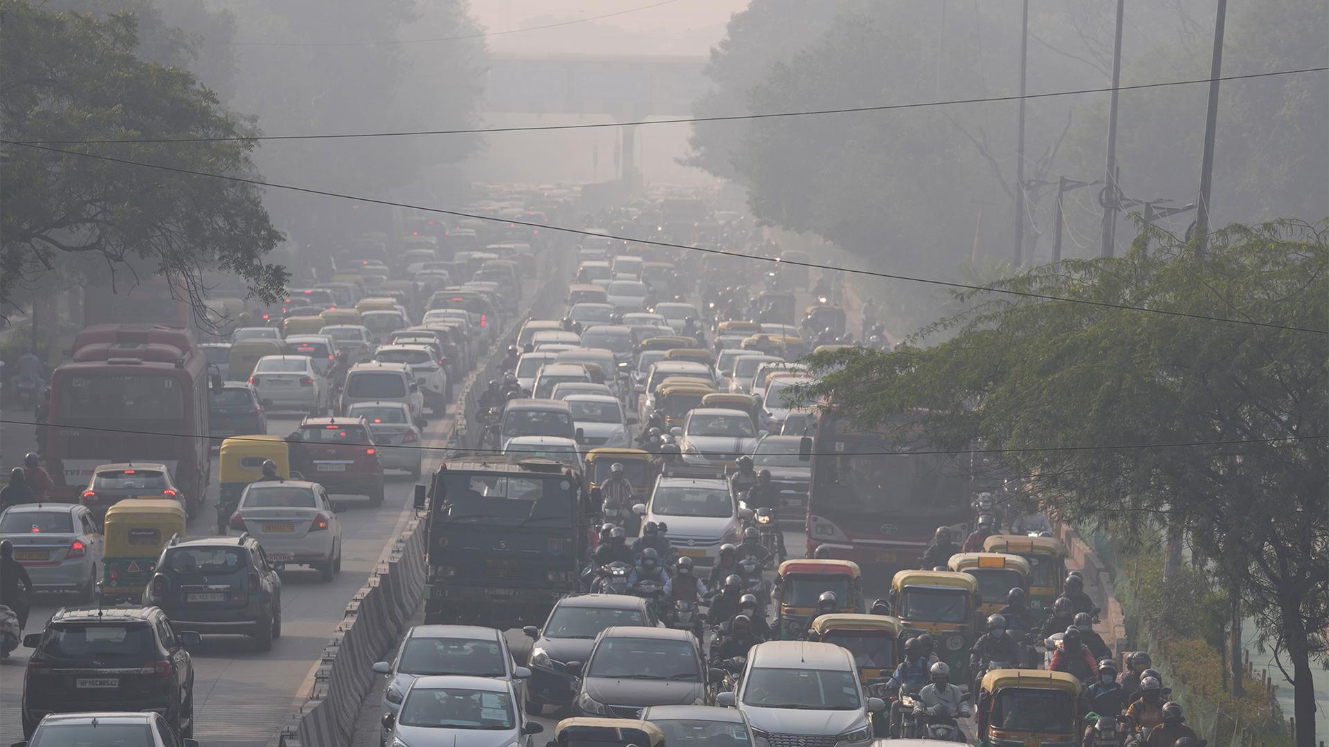 Commuters drive amidst morning haze and toxic smog as schools and some coal-based power plants close down in New Delhi, India
