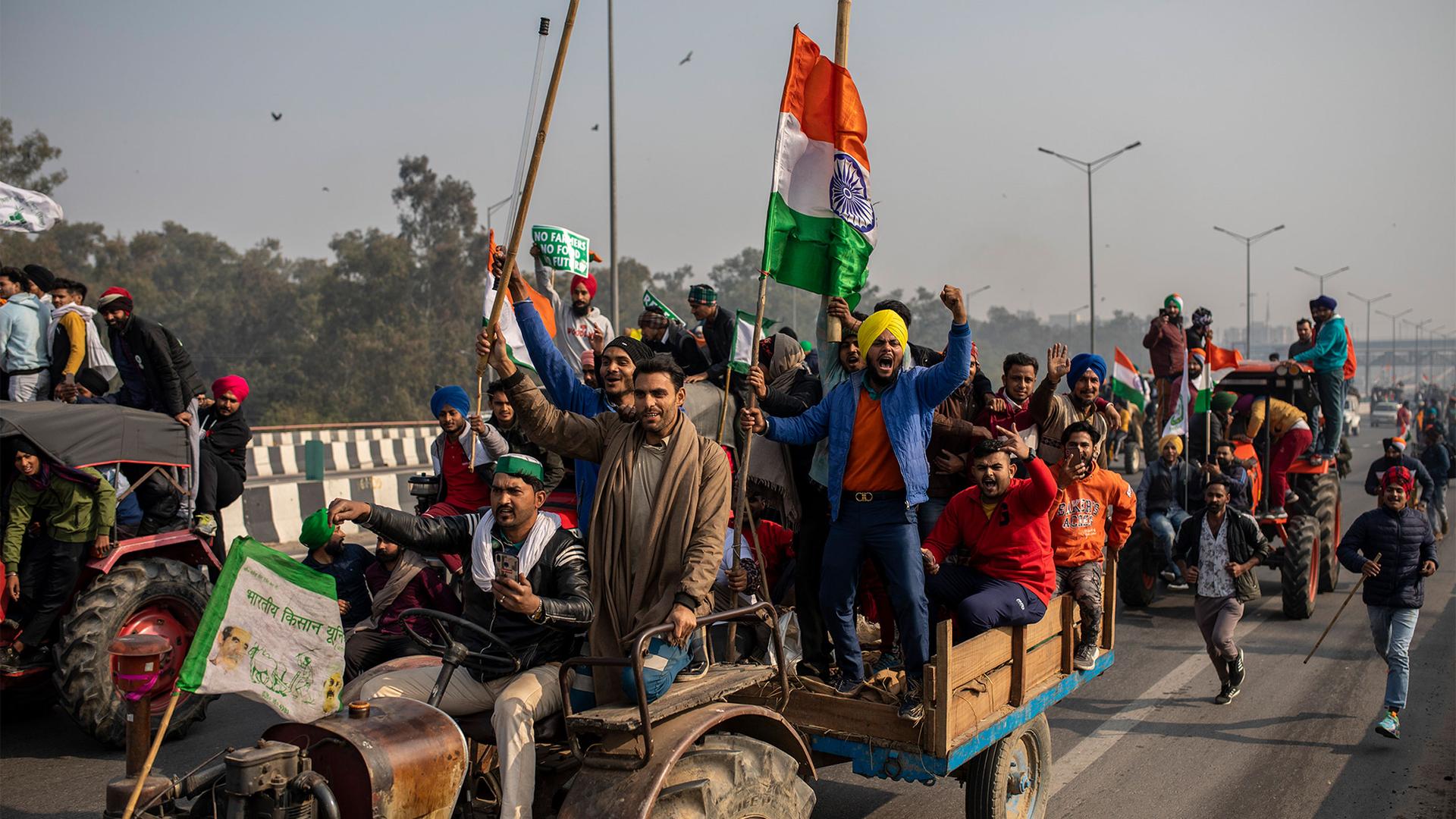 Protesting farmers ride tractors and shout slogans as they march to the capital, breaking police barricades, during India's Republic Day celebrations in New Delhi, India