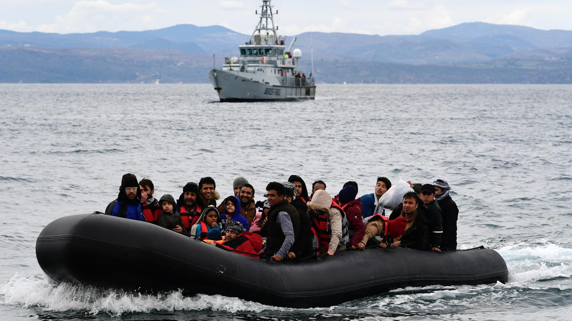 Migrants arrive aboard a dinghy accompanied by a Frontex vessel at the village of Skala Sikaminias, on the Greek island of Lesbos, after crossing the Aegean sea from Turkey, Feb. 28, 2020. 