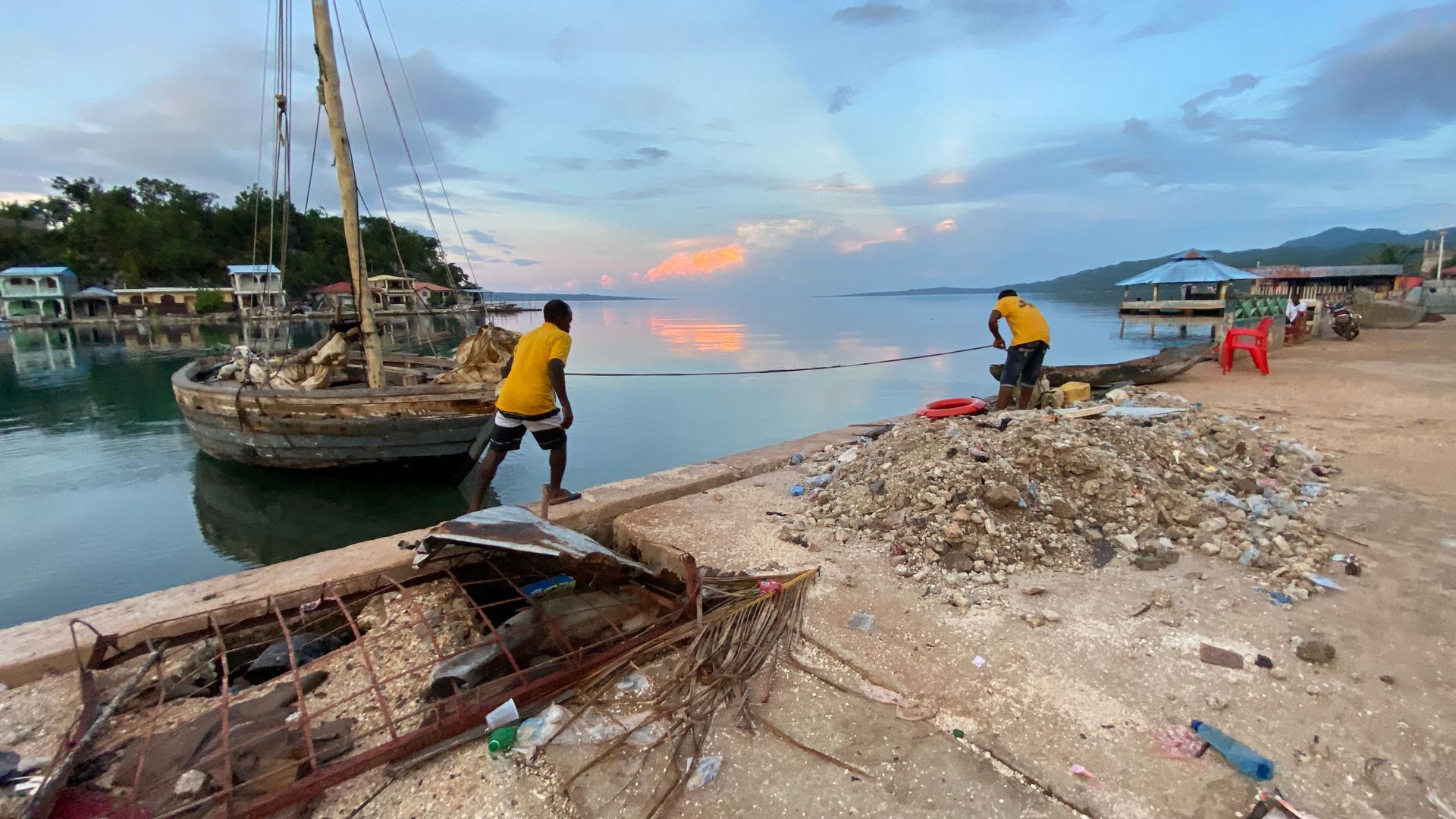 In Pestel, Haiti, on the country's southern peninsula, Jean-Robert Leger, left, brings in a boat that is a bit smaller than the one he has attempted in to sail to the United States, along with many other migrants aboard.