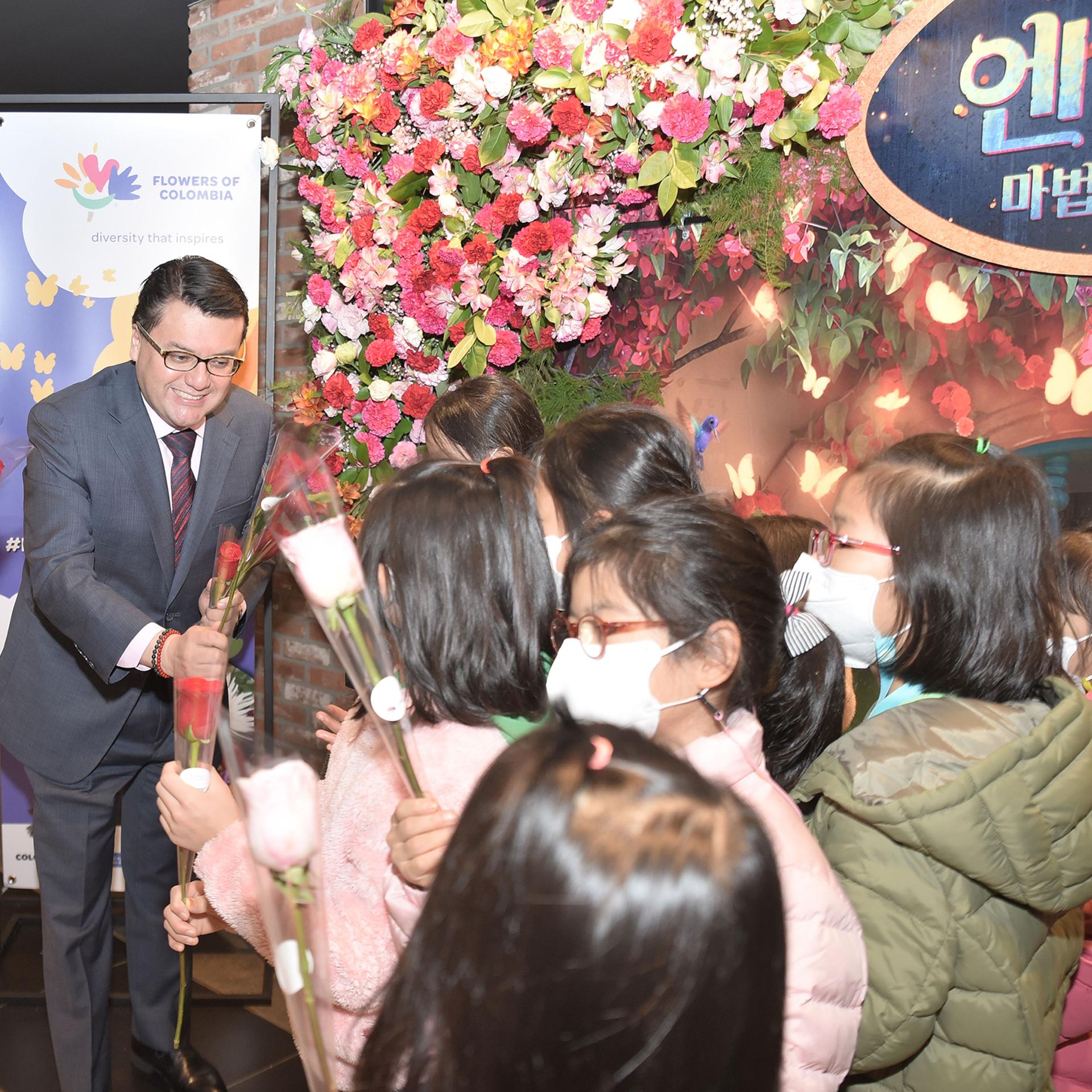 Colombia's ambassador to South Korea hands out flowers to children during the premiere of 