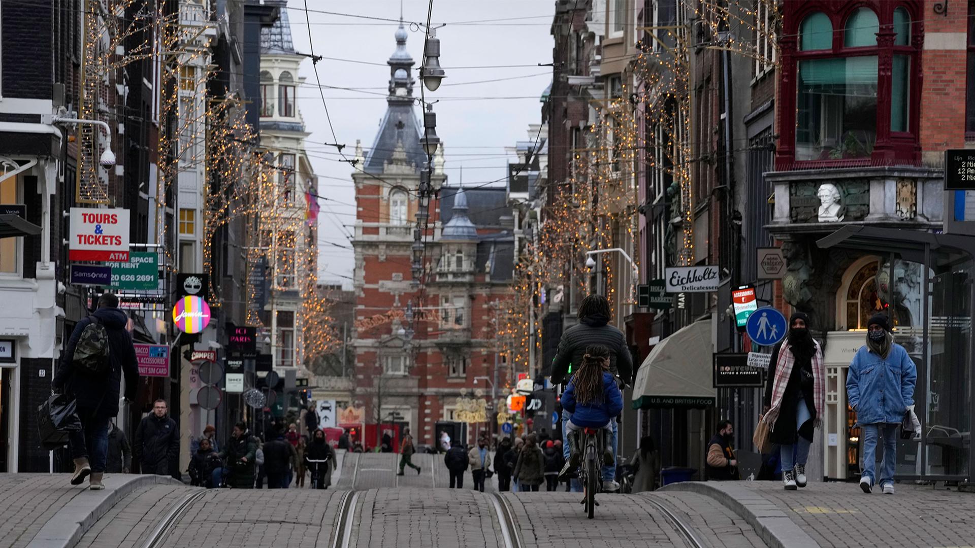 People walk down a normally bustling shopping street in the center of Amsterdam