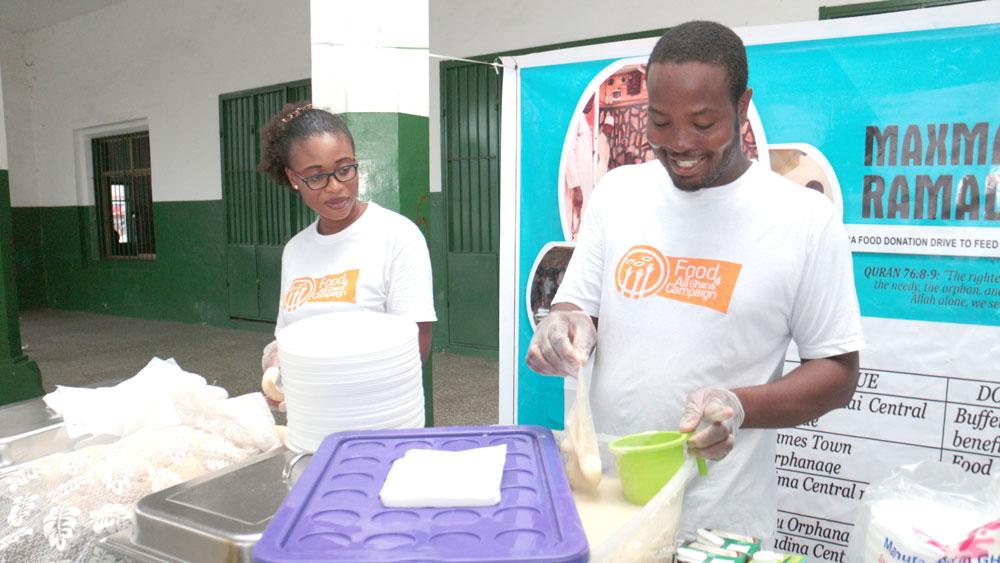 Chef Elijah Amoo Addo (right) prepares food to distribute as part of Food for All Africa. 