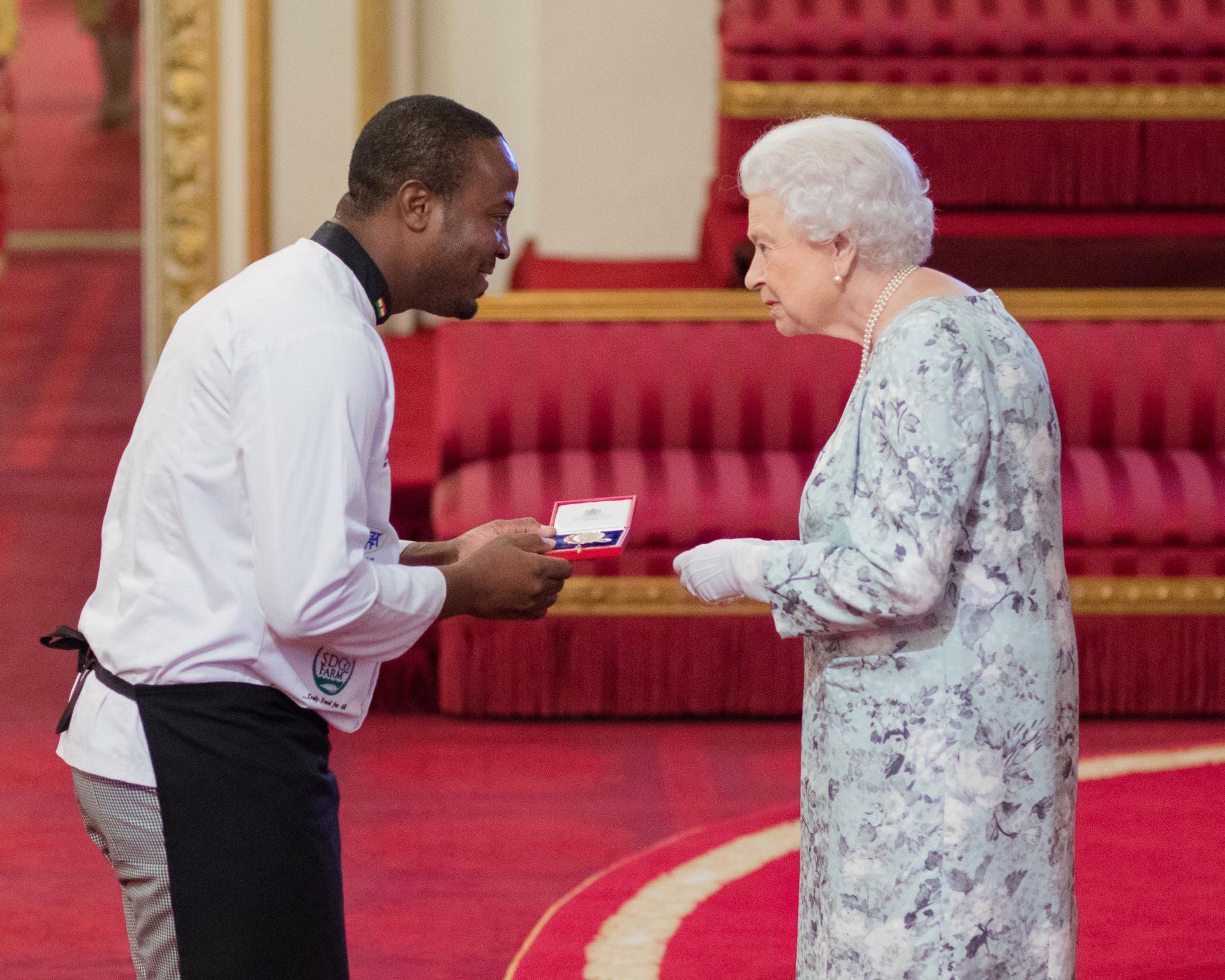 Chef Amoo Addo receives an award from the queen of England.