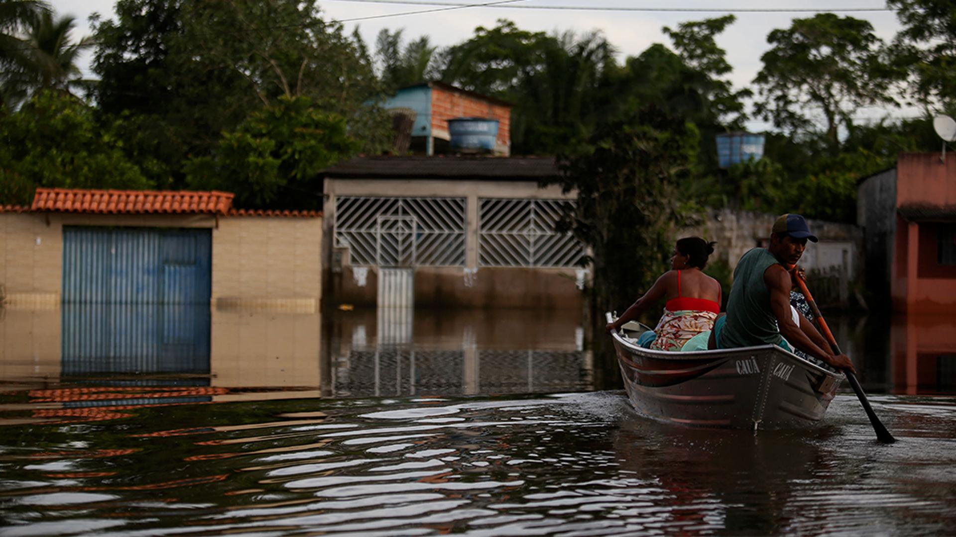 Luzia Barbosa de Oliveira, not pictured, is transported on a boat to her home partially submerged by flood waters in Sambaituba, a rural area of Ilheus, Bahia state, Brazil.