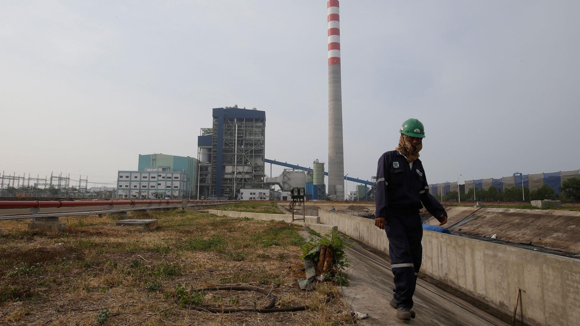 In this Oct. 17, 2014, photo, a worker walks at power plant area in Cirebon, Indonesia. 