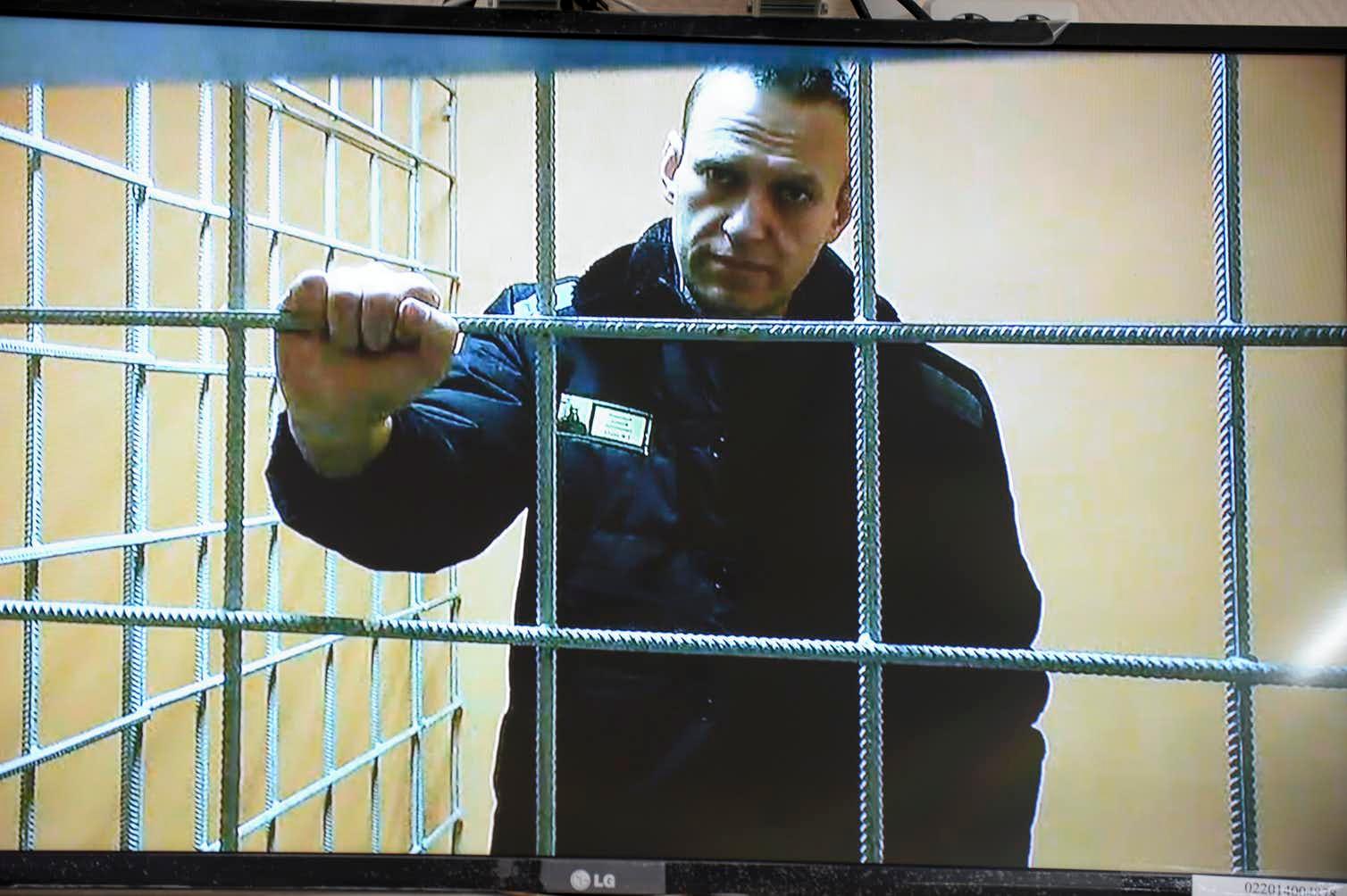 Alexei Navalny standing behind bars