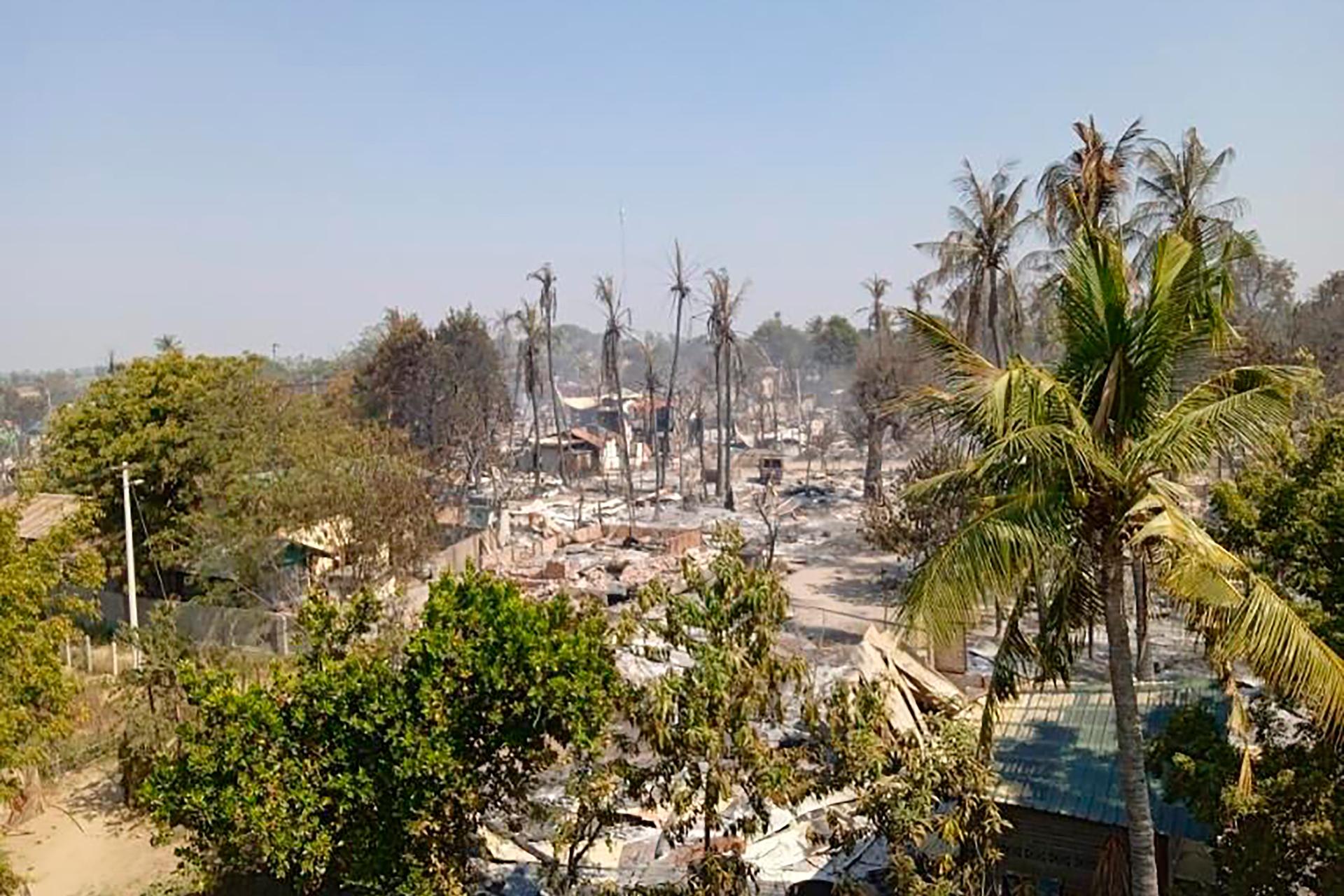 Charred houses sit in ash between the trees in Mwe Tone village of Pale township in the Sagaing region, Myanmar on Feb. 1, 2022. Mwe Tone was one of two villages residents and Myanmar news outlets said were burned down Monday, Jan. 31, 2022, by soldiers t