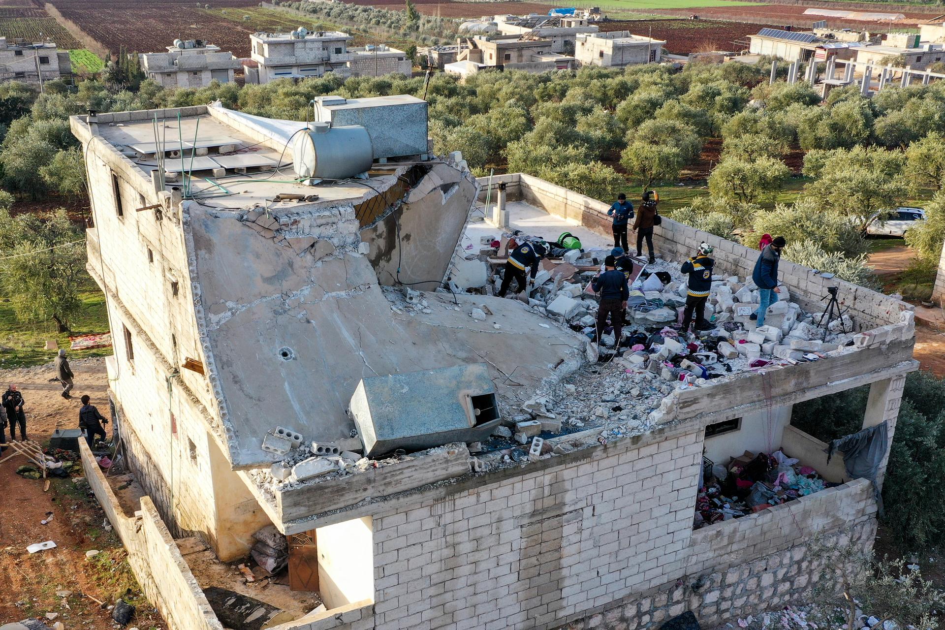 People inspect a destroyed house following an operation by the US military in the Syrian village of Atmeh, in Idlib province, Syria, Feb. 3, 2022. 