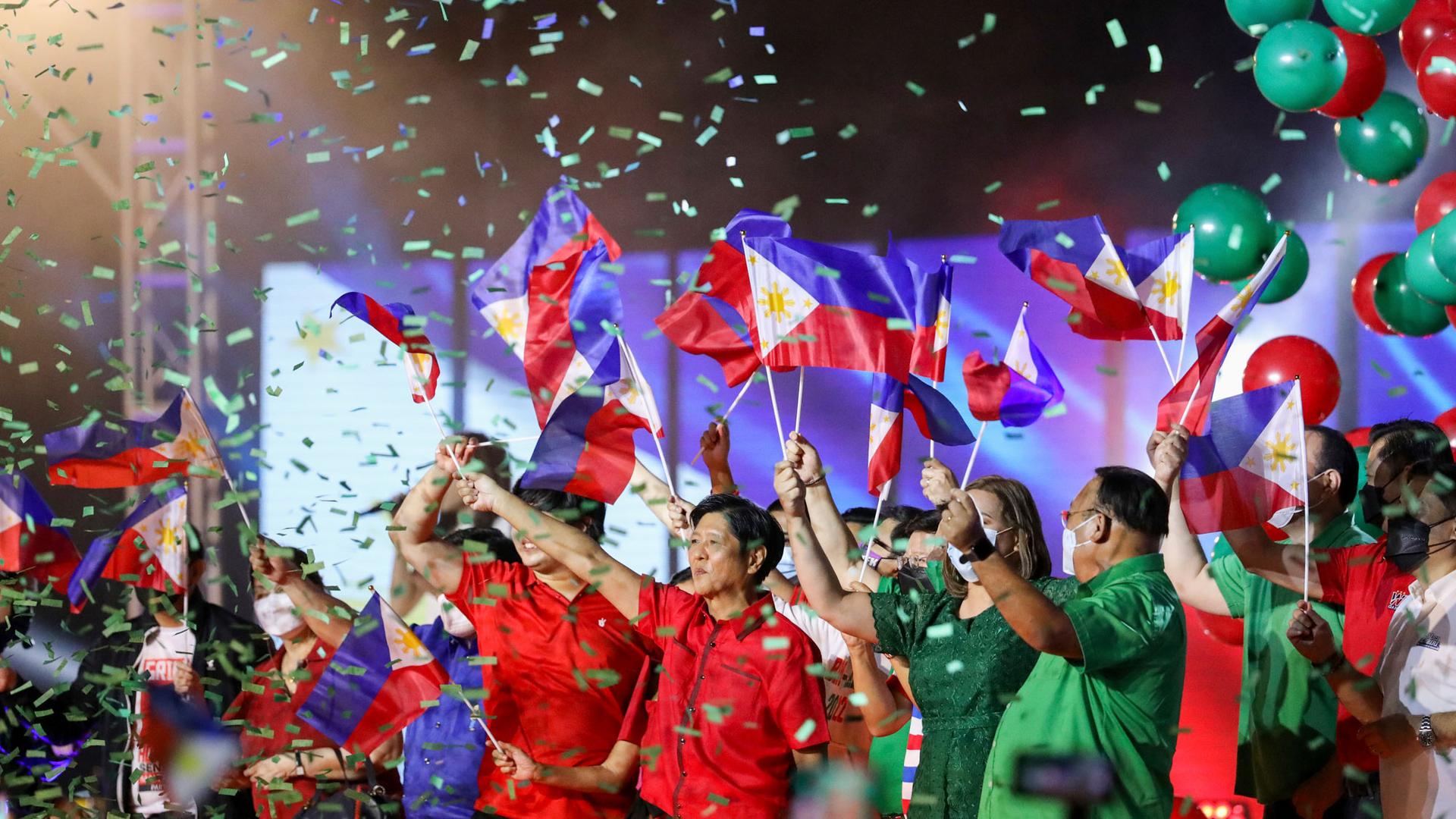 Former senator Ferdinand "Bongbong" Marcos Jr. and his team wave Philippine flags on stage during his proclamation rally promoting his presidential bid for the 2022 national elections, at Philippine Arena, Bulacan province, north of Manila, Philippines.