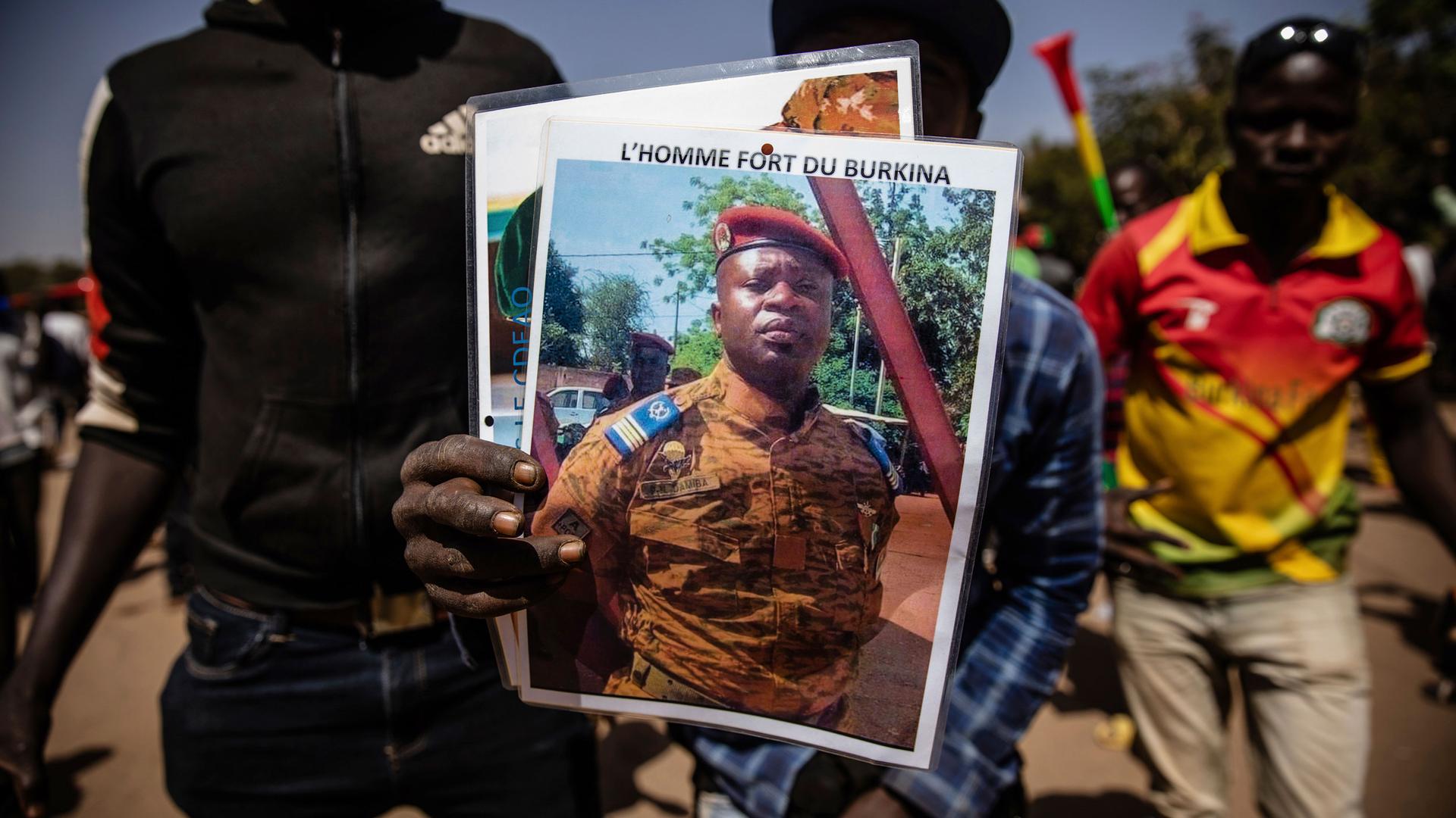 A man holds a portrait of Lt. Col. Paul Henri Sandaogo Damiba who has taken the reins of Burkina Faso, in Ouagadougou, Jan. 25, 2022. 