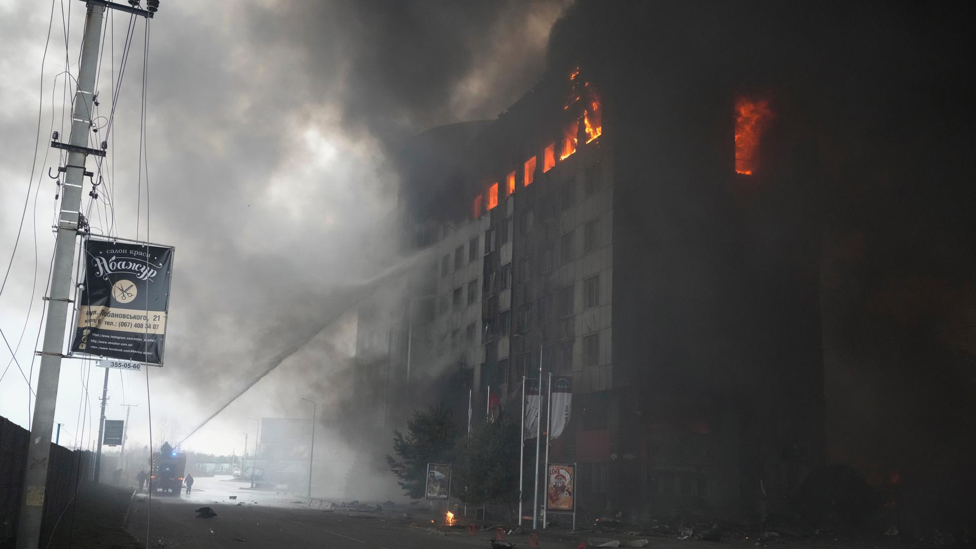 Firefighters hose down a burning building after bombing in Kyiv, Ukraine, March 3, 2022. Russian forces have seized a strategic Ukrainian seaport and besieged another. Those moves are part of efforts to cut the country off from its coastline even as Mosco