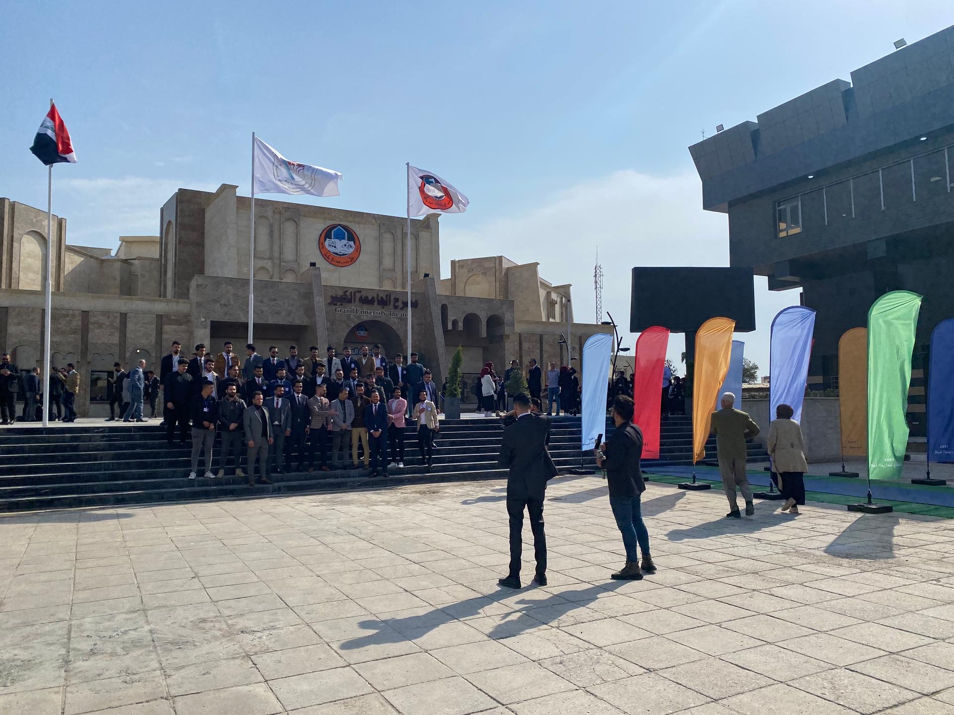 Students gather to take a group picture during the library repat the University of Mosul in front of the theatre on Feb. 19, 2022.