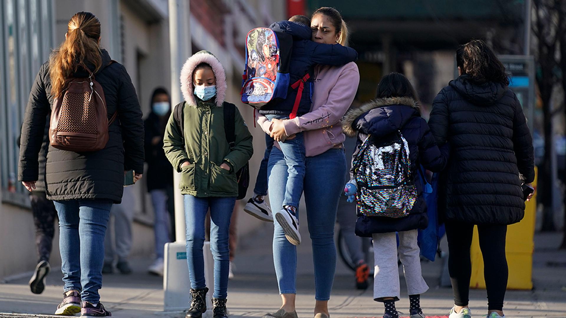 Children and their caregivers arrive for school in New York