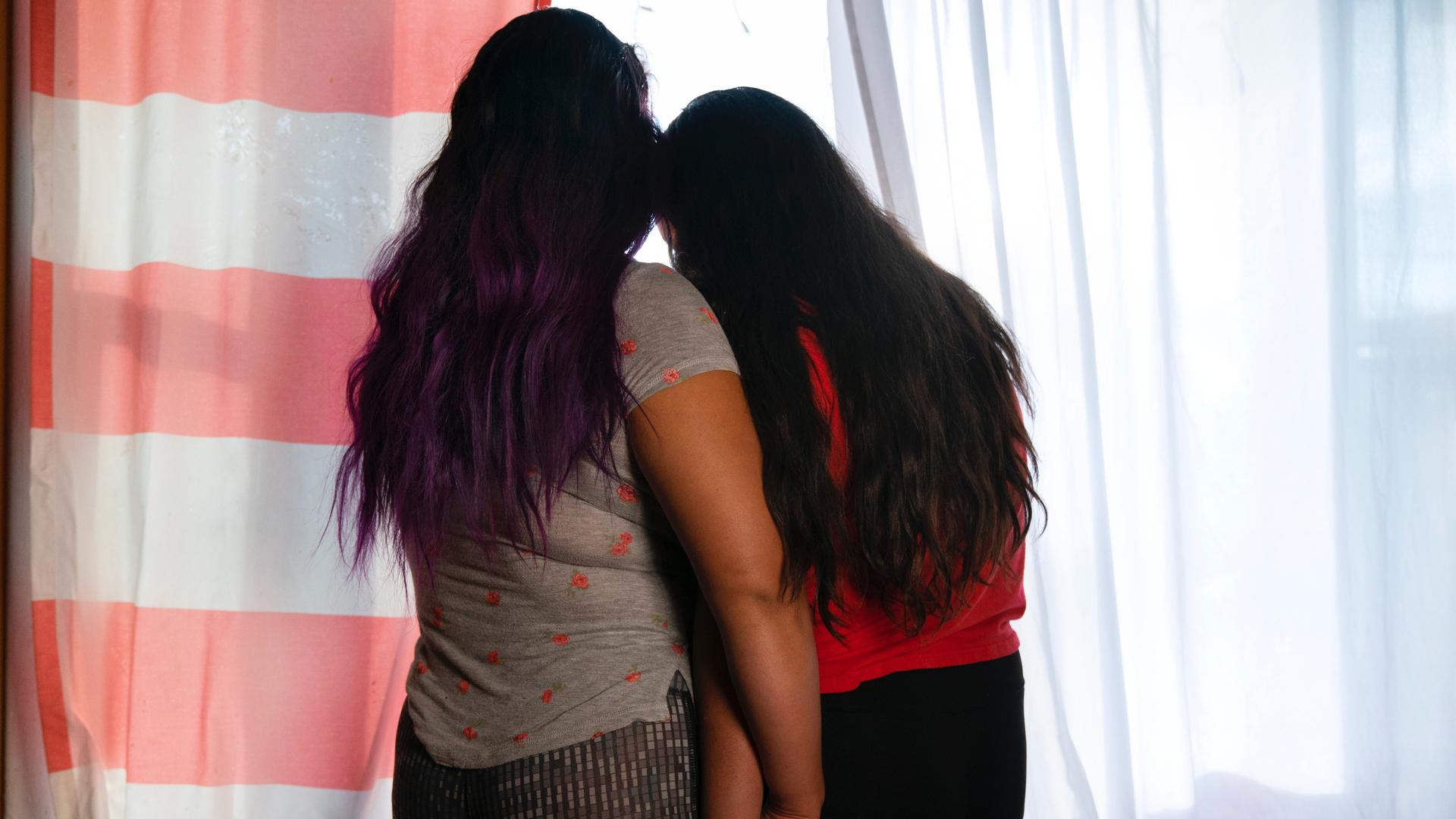 Jacqueline Flores, left, holds hands with her daughter Nicky at their home in Virginia, July 14, 2021. 