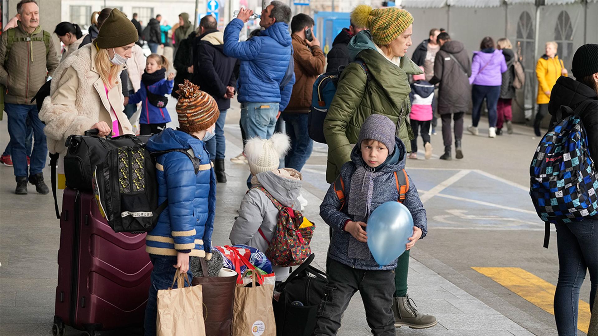 Ukrainian refugees wait for a transport at the central train station in Warsaw, Poland