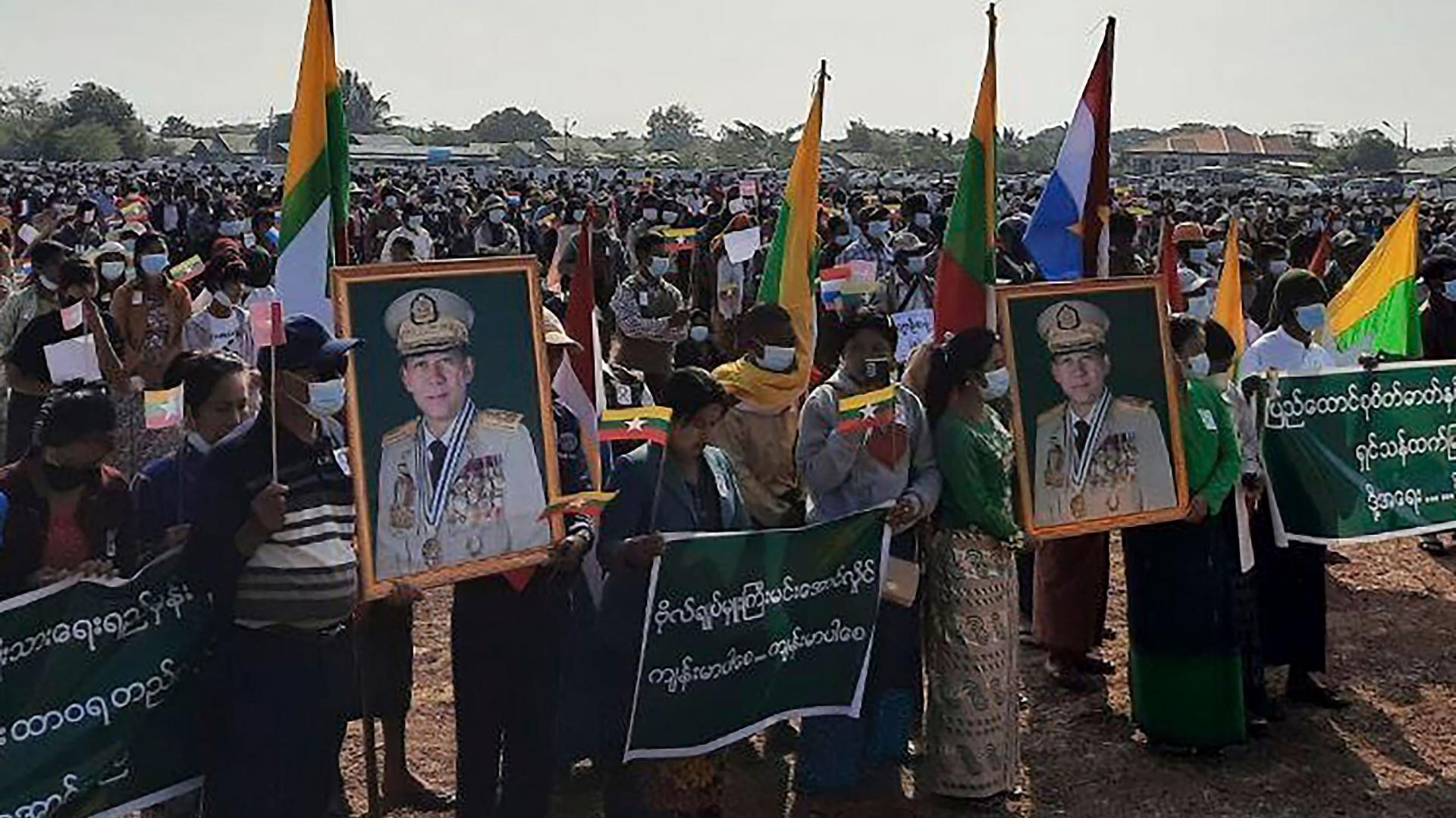 In this image provided by the Military True News Information Team, supporters of the military government hold nationalistic banners and portraits of Senior General Min Aung Hlaing, chairman of the State Administration Council.