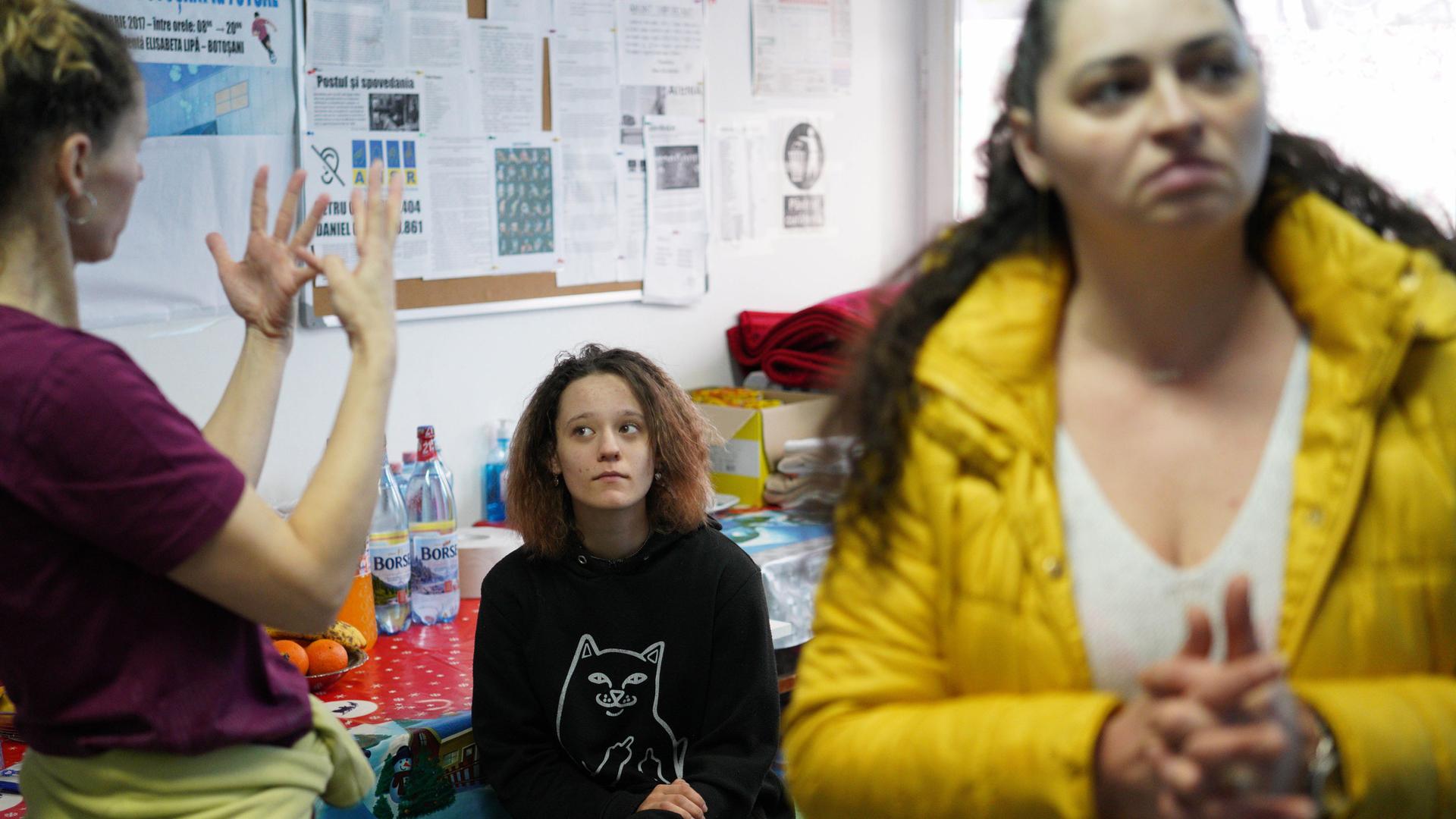 Olga Sviridenko (left), who is deaf, signs with her family at a shelter in Romania. 